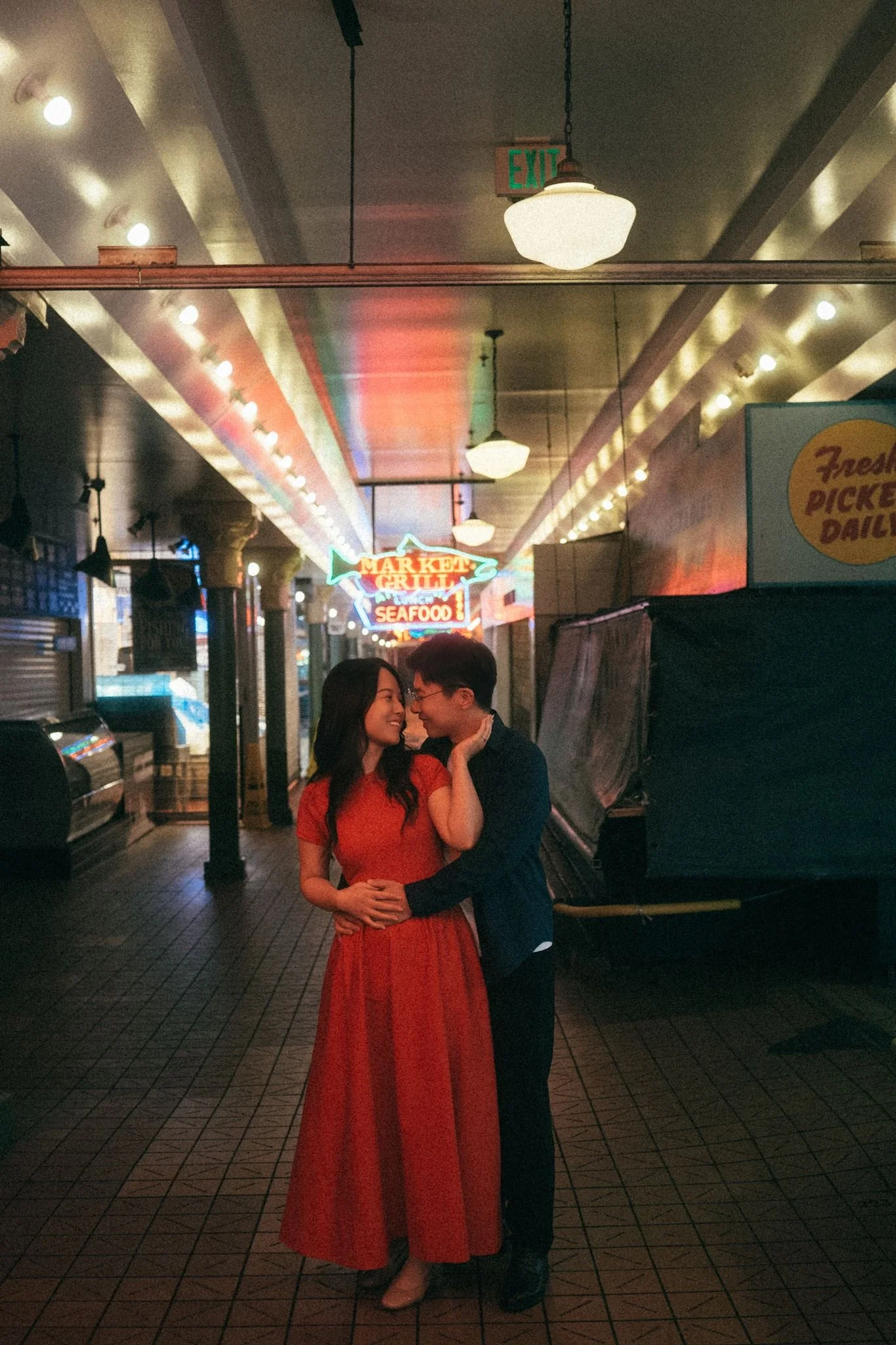 asian couple during their seattle engagement at pike place market