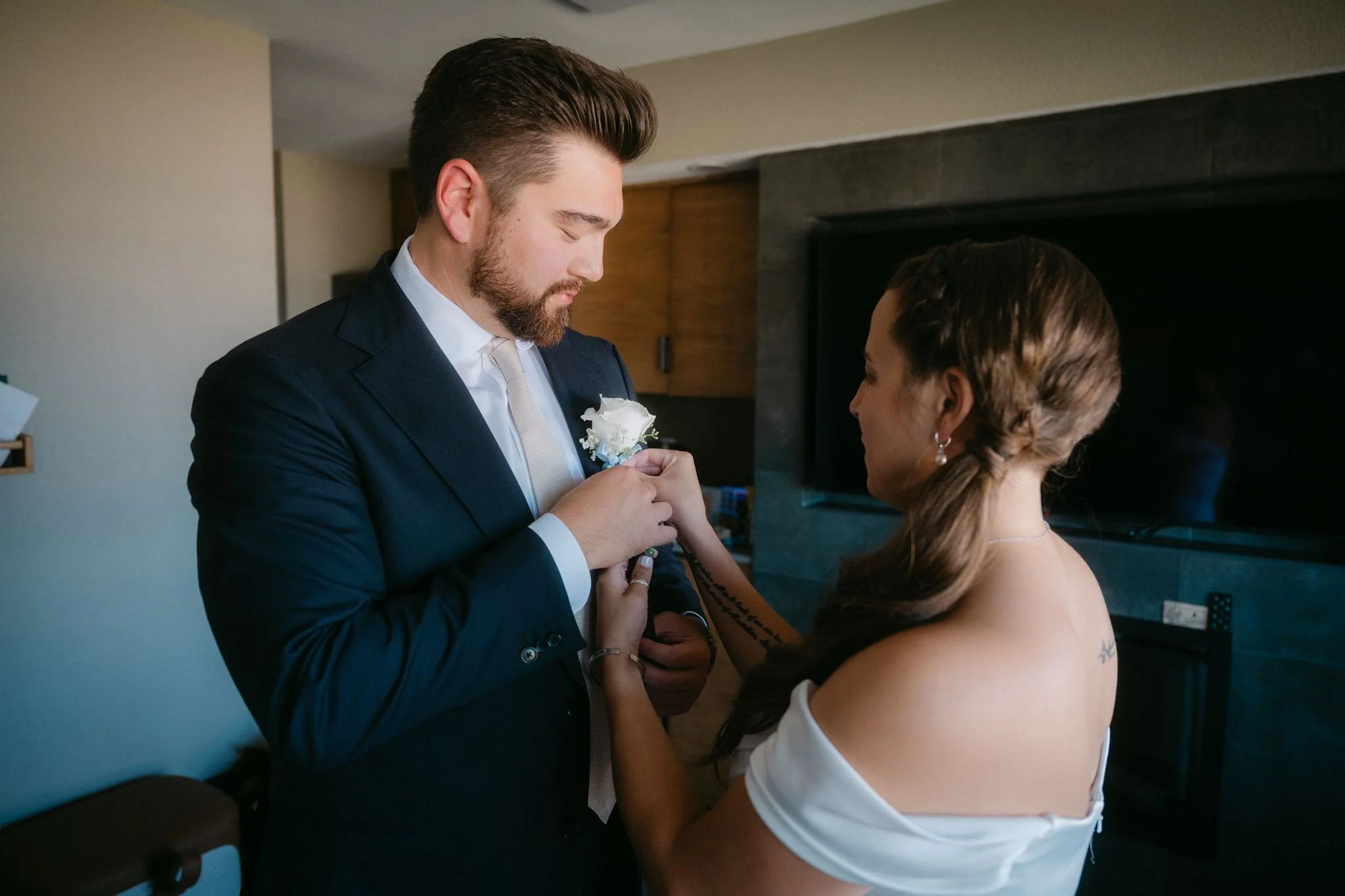 bride adjusting groom's boutonniere