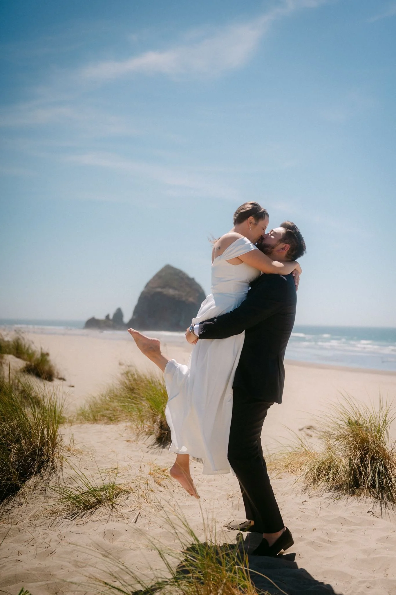playful wedding couple at the beach during their cannon beach wedding on the oregon coast