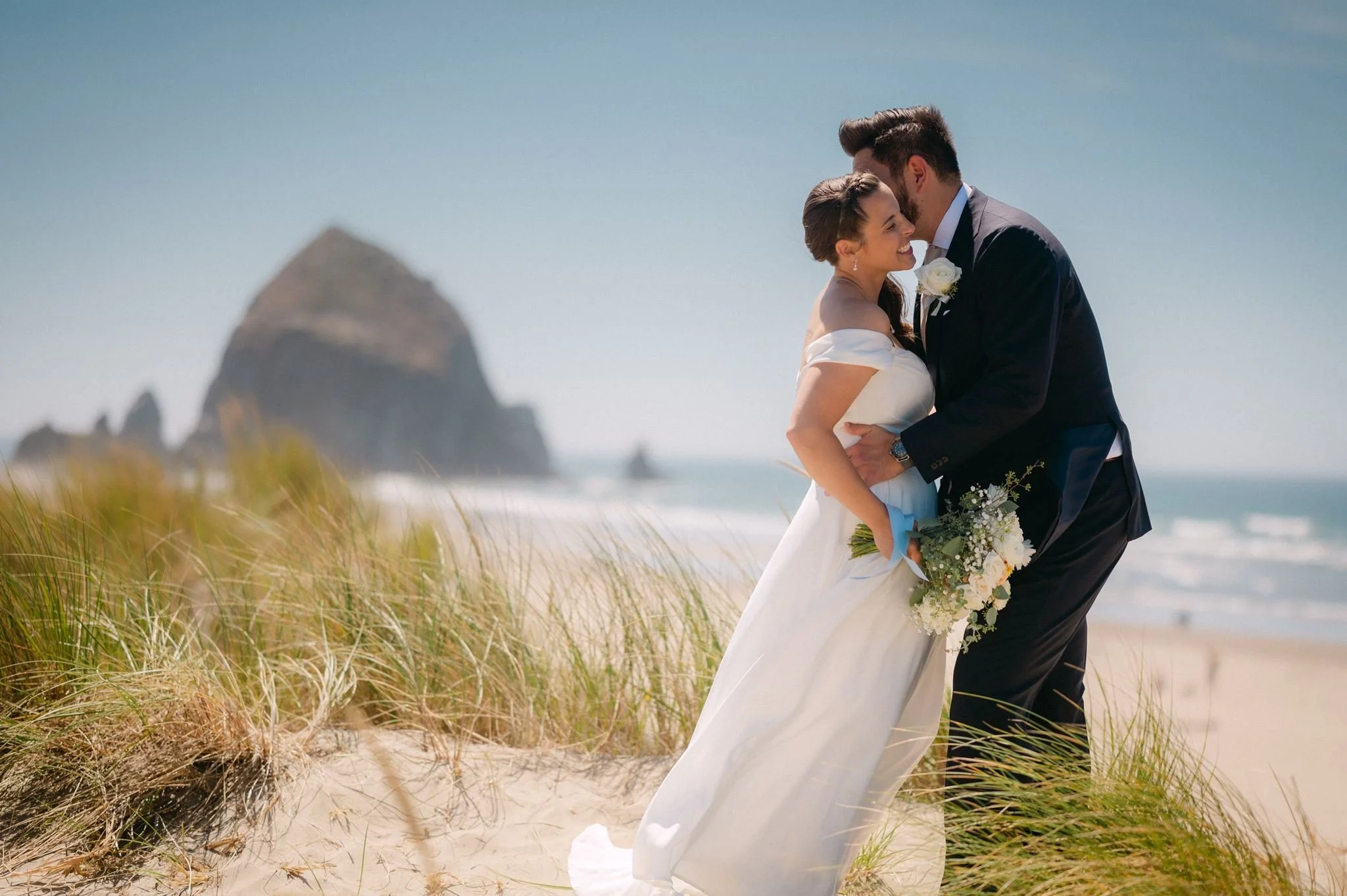playful wedding couple at the beach during their cannon beach wedding on the oregon coast