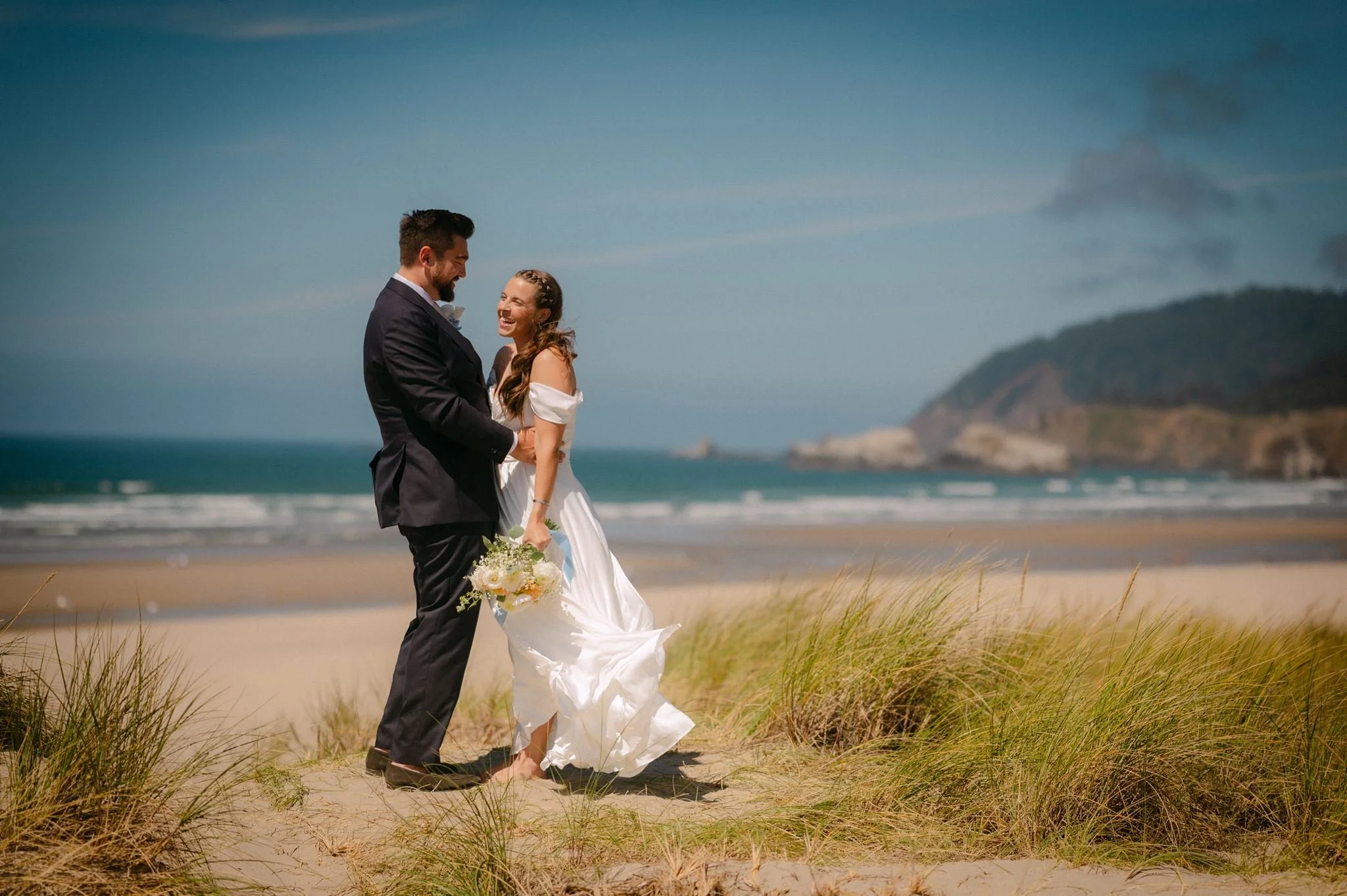 playful wedding couple at the beach during their cannon beach wedding on the oregon coast