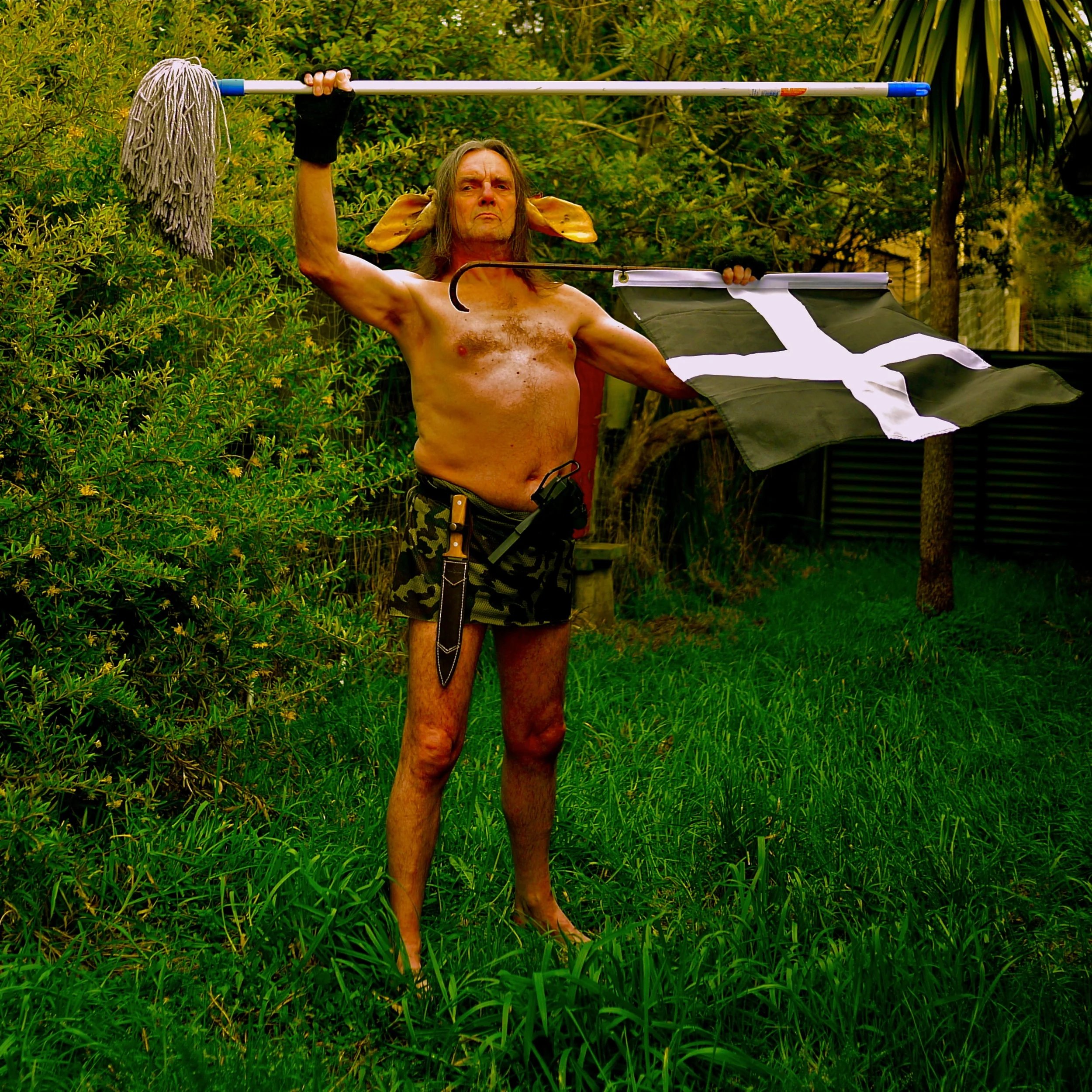 Man of Curnow - at the request of Andre Stitt. W ith Cornish Flag, Mach 10 machine pistol, pig sticker, and Floor Mop. 2012. 2m X 2m archival photograph.