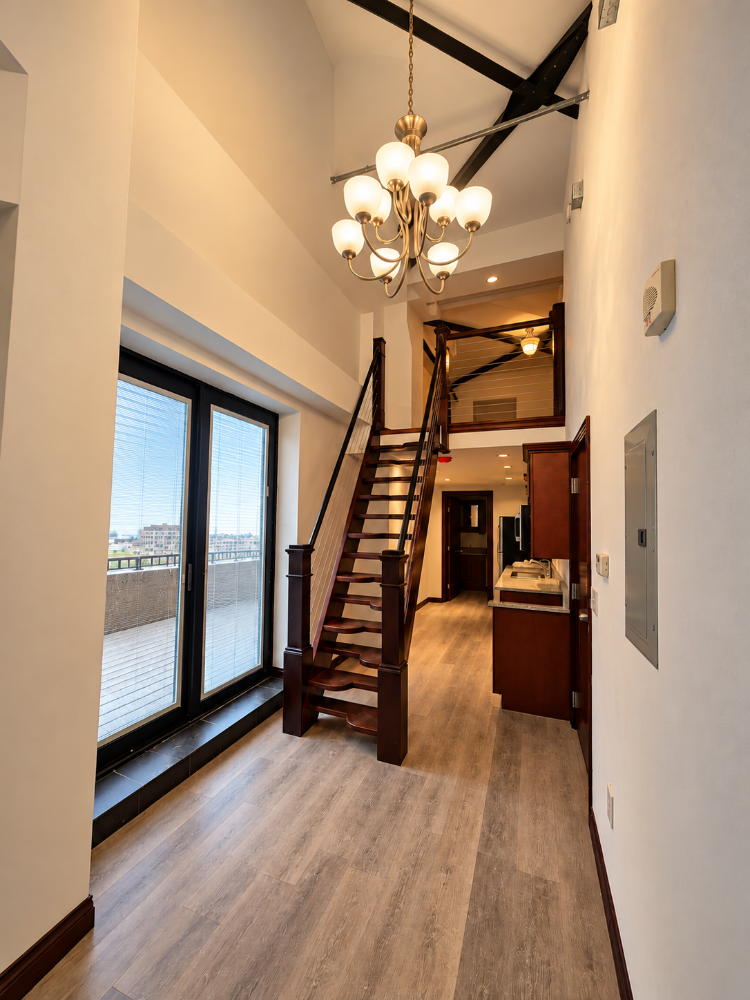 Modern Loft Entry with Chandelier and Staircase.png