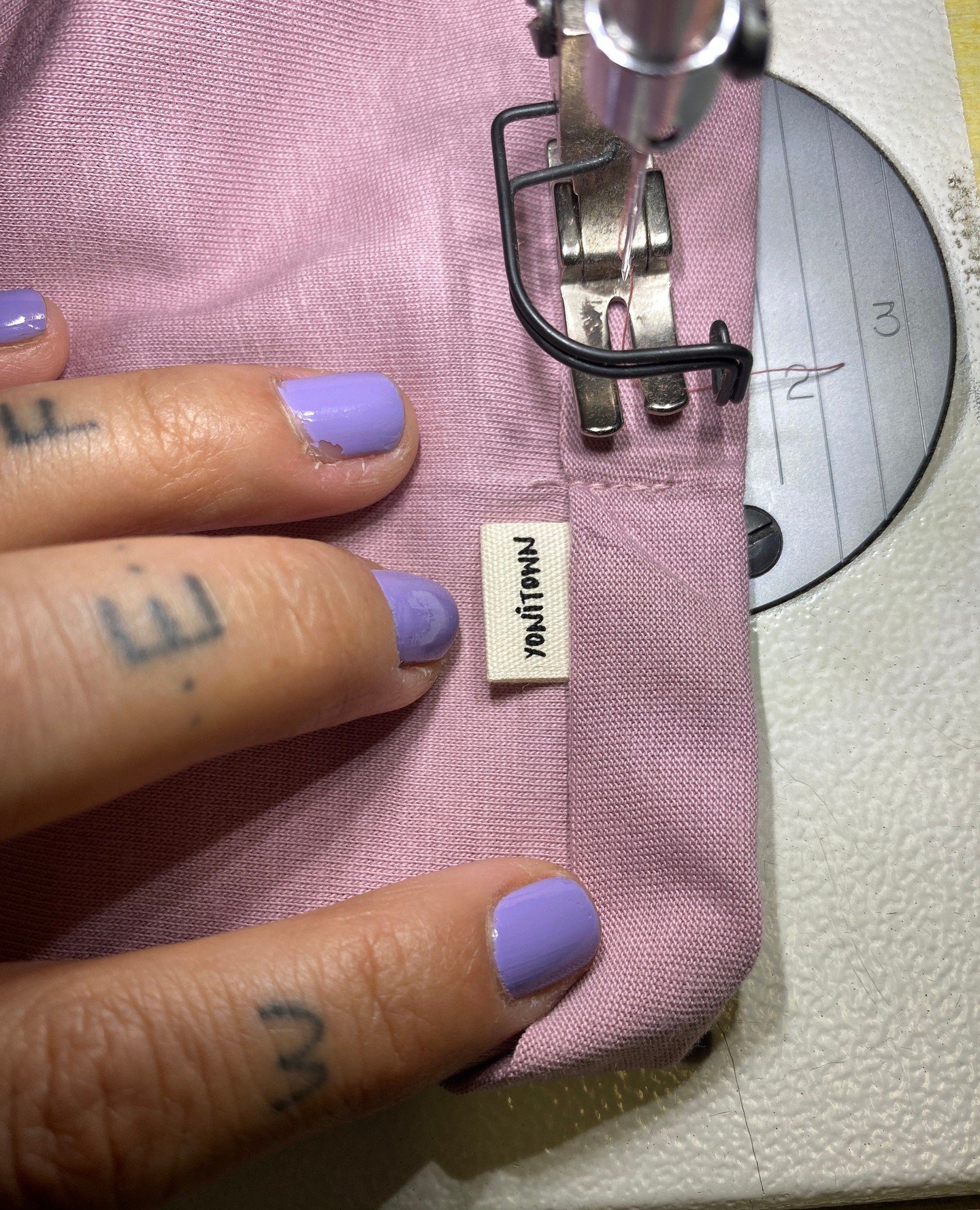 Lavender tones captured at the studio 💜⁠
⁠
1 Sewing our tiny labels on the sleeve of the Golden Vulva Heart crop top.⁠
2 Printing Thirdie on the back of the Oversized tee.⁠
3 Back pattern piece of Yoni Undies are being printed.⁠
⁠
Often I get asked 