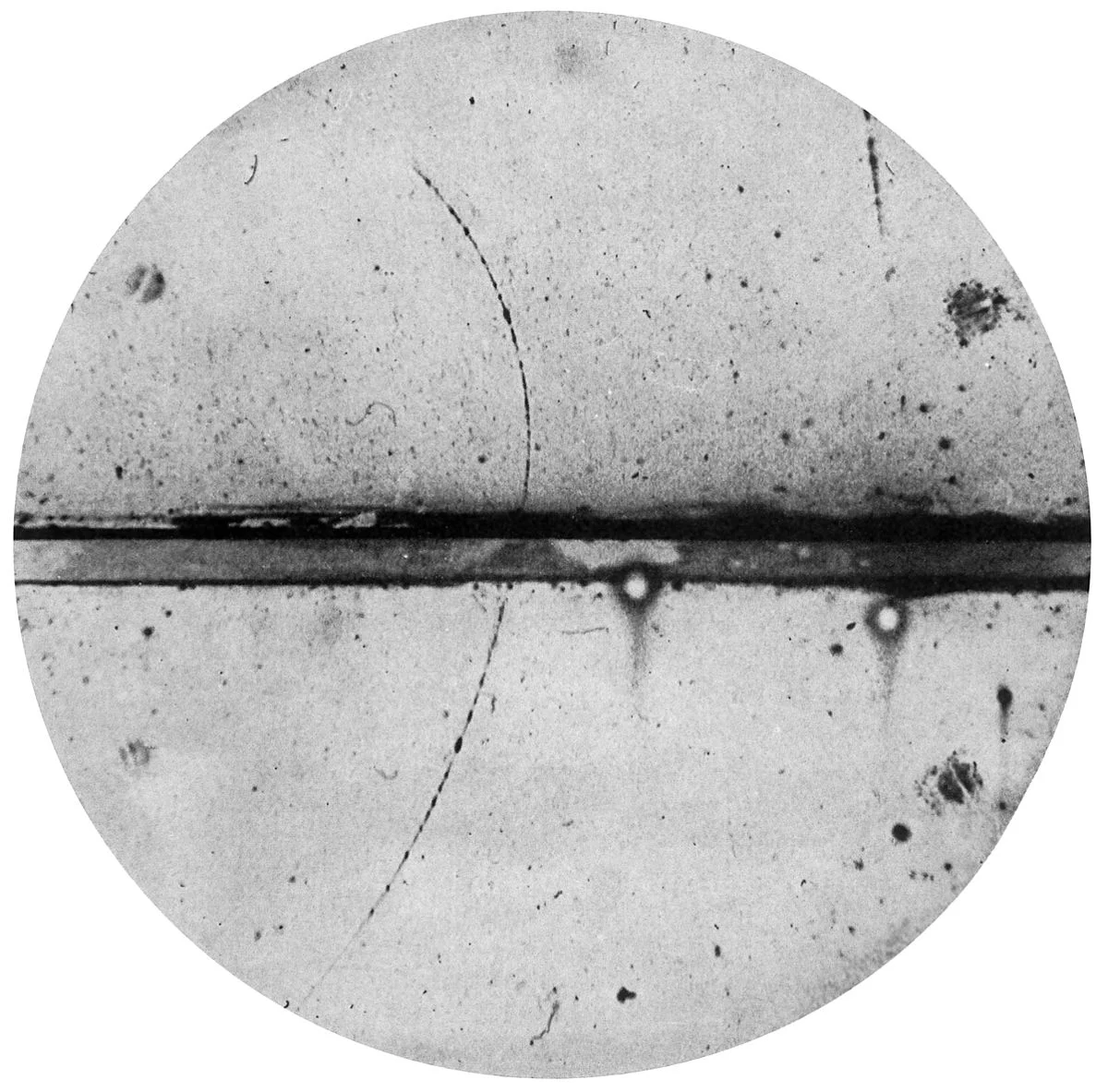 Cloud chamber photograph of the first positron identified by Carl Anderson. The existence of such a particle (the anti-electron) was mentioned in passing by Dirac in his 1931 paper on quantization of electric charge.