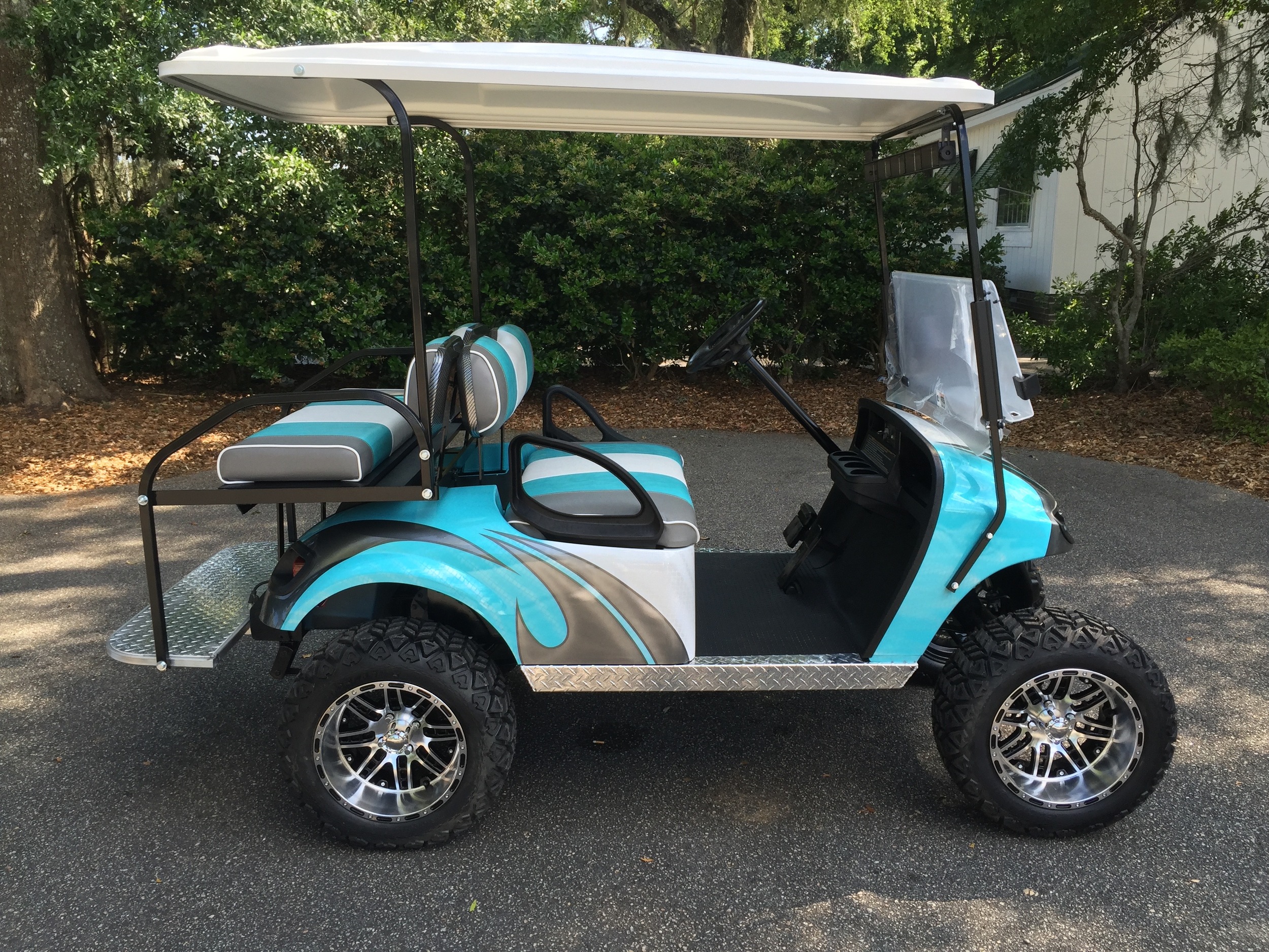 Aqua Swirl EZGO Lifted Cart Aqua/smoke/white seats, white extended top, new batteries, high speed code, LED lights, Backlash (23x10x14) tires, mirror, flip windshield, and state of charge meter