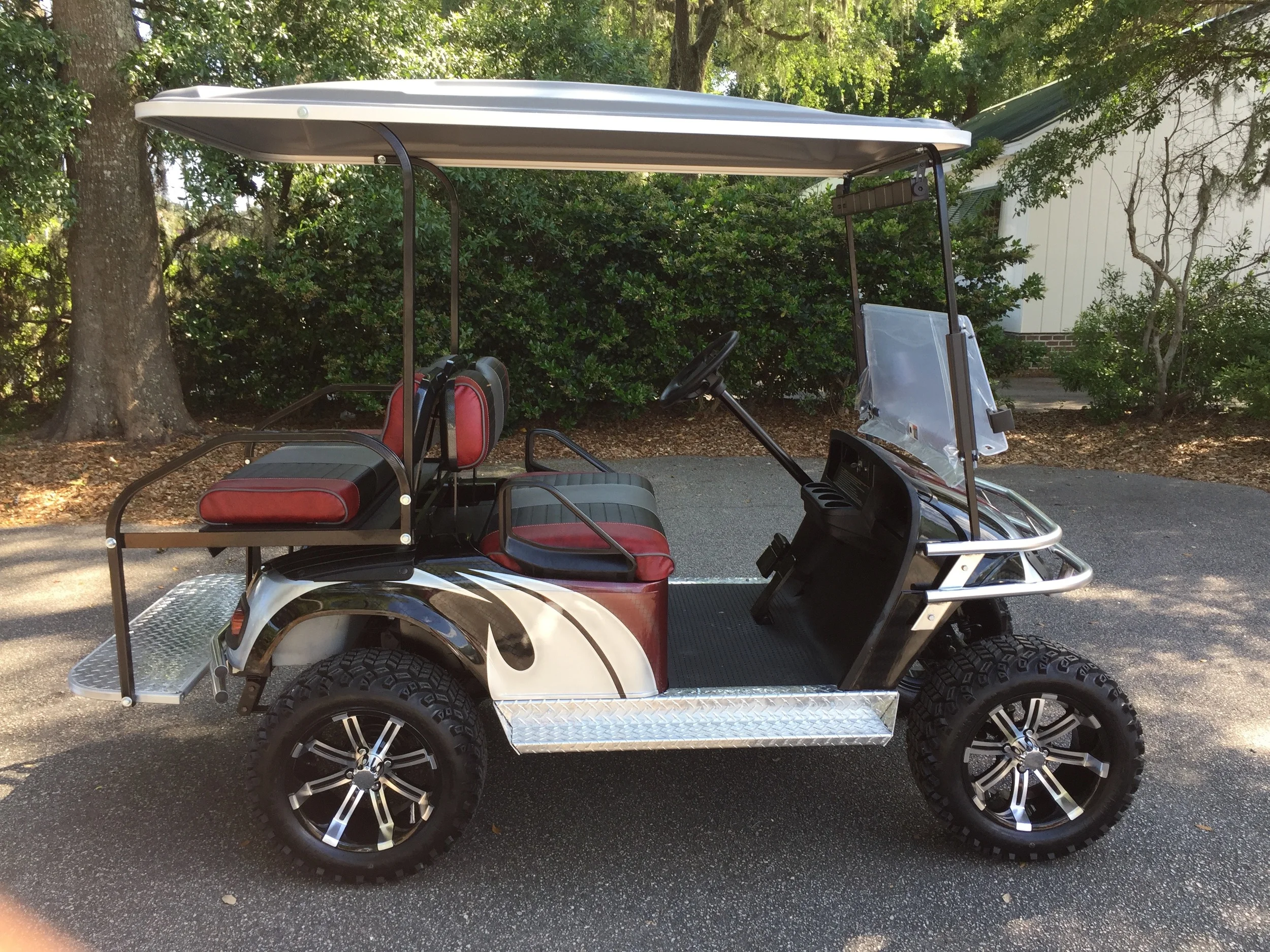 Burgundy Swirl EZGO Lifted Cart Burgundy/black/smoke seats, black extended top, new batteries, high speed code, LED lights, Backlash (23x10x14) tires, chrome brush guard, running board, and rear guard, mirror, flip windshield, and state of charge meter