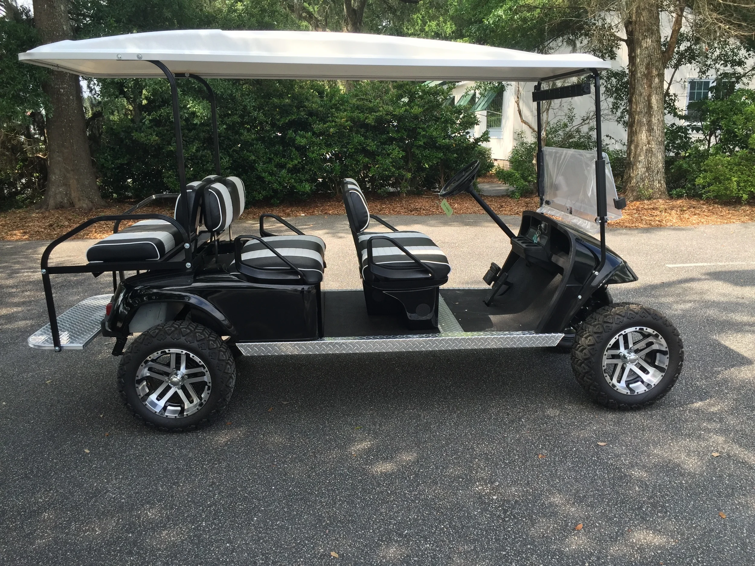 Black EZGO Lifted Trolley Black/white seats, white top, new batteries, high speed code, LED lights, Backlash (23x10x14) tires, state of charge meter, mirror, and flip windshield
