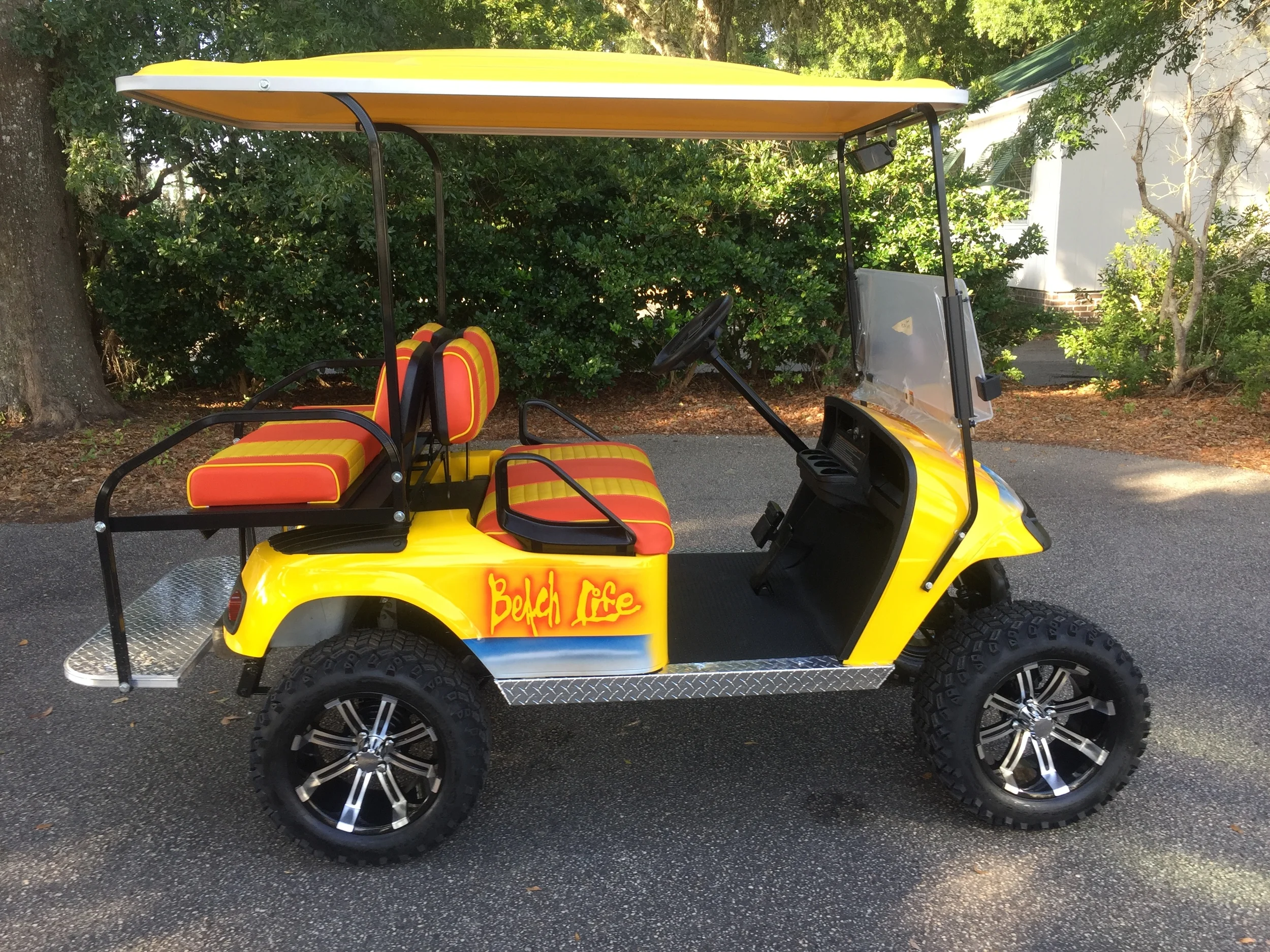 Yellow Beach Life EZGO Lifted Cart Yellow/orange seats, yellow extended top, new 2018 (6-8vt) batteries, high speed code, LED lights, Backlash (23x10x14) tires, mirror, rear cup holders, flip windshield, and state of charge meter