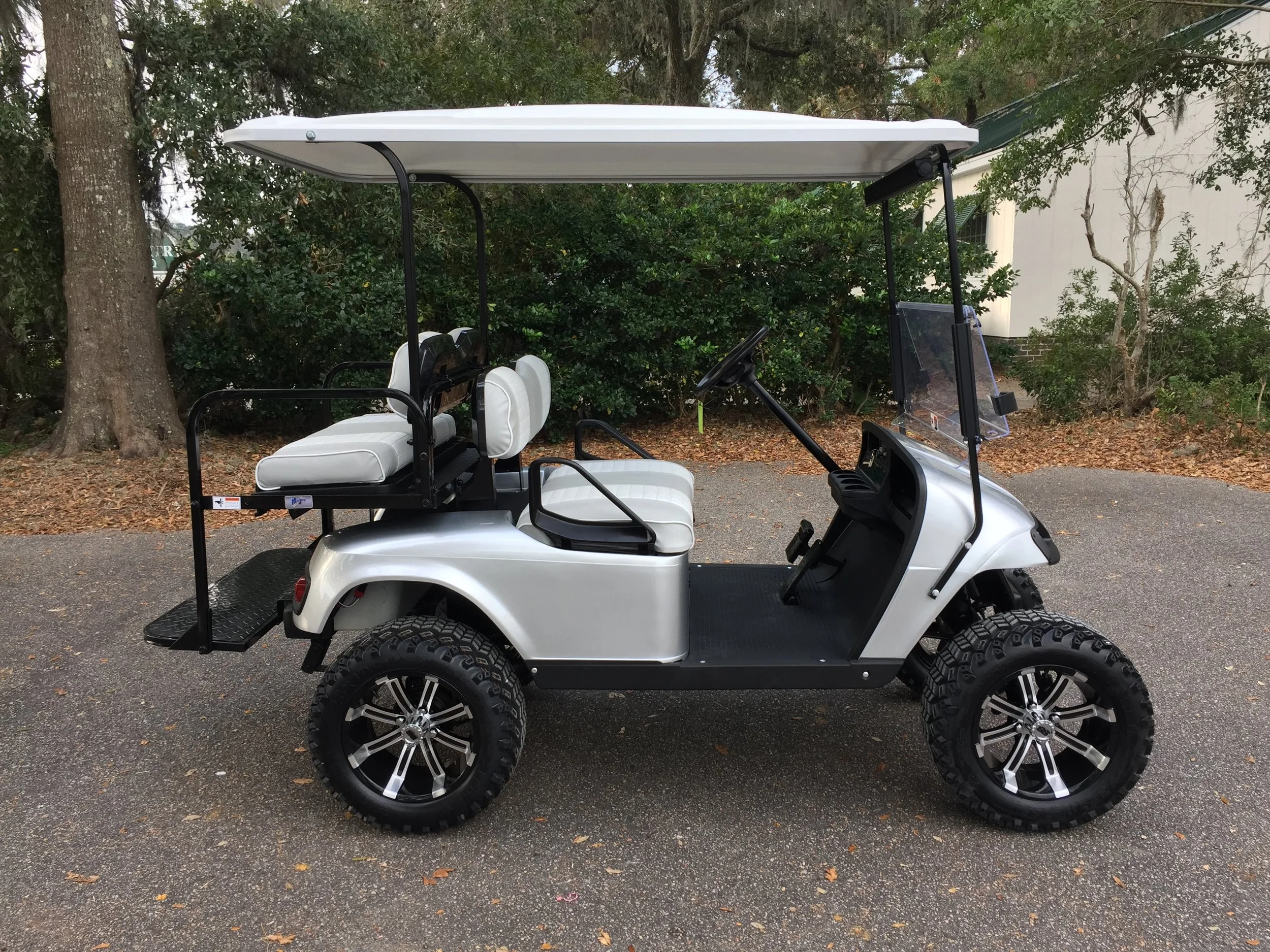 Silver EZGO Lifted Cart Silver/white seats, white extended top, new batteries, LED lights, Backlash (23x10x14) tires, high speed code, state of charge meter, mirror, and flip windshield