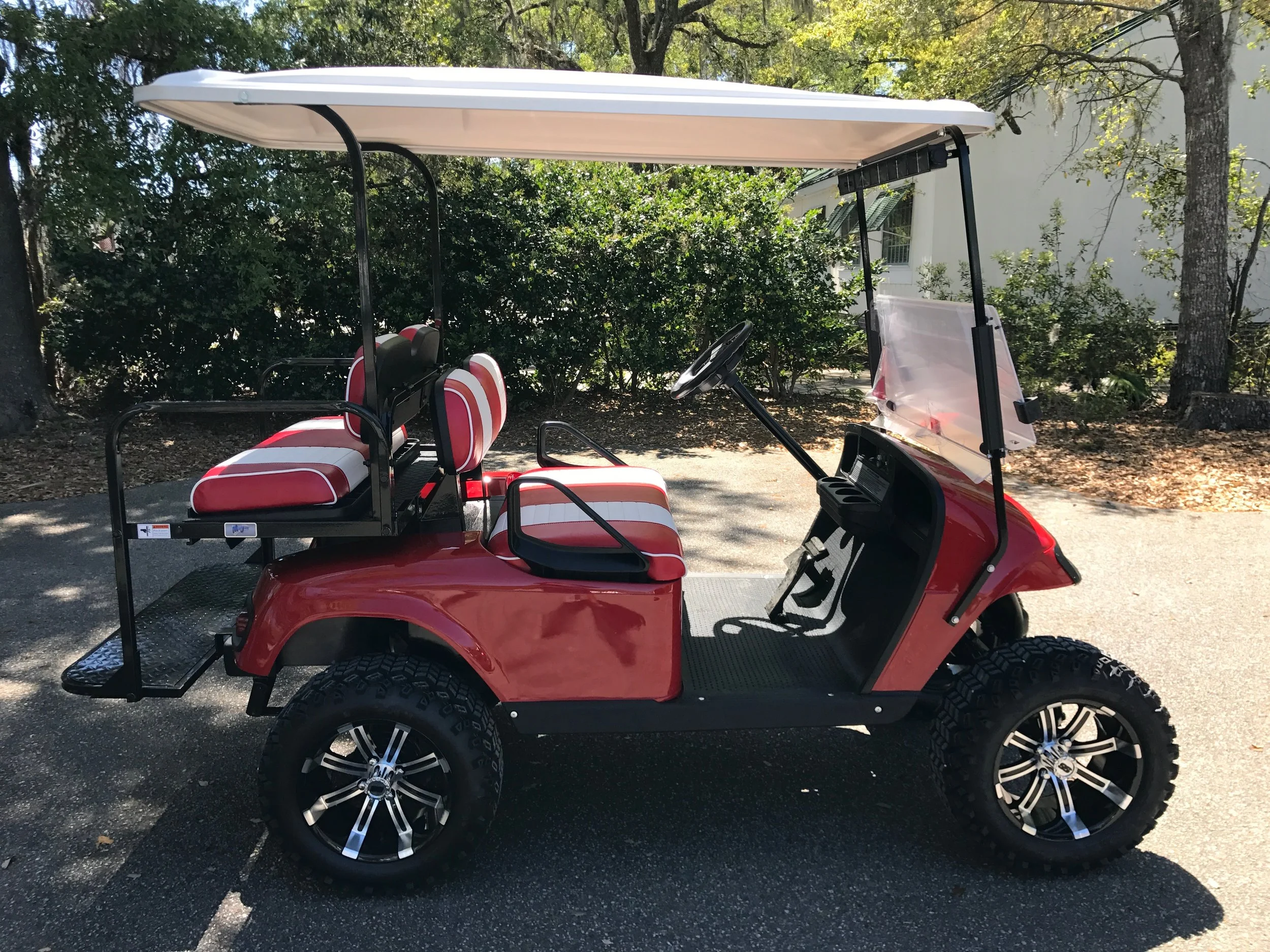 Red EZGO Lifted Cart Red/white seats, white extended top, new batteries, high speed code, LED lights, Backlash (23x10x14) tires, mirror, flip windshield, and state of charge meter