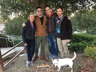 Judy and her sons, Cameron, Ryland, and Stewart with Shorty at the memorial tree for Judy's husband, Bryan, three years ago.