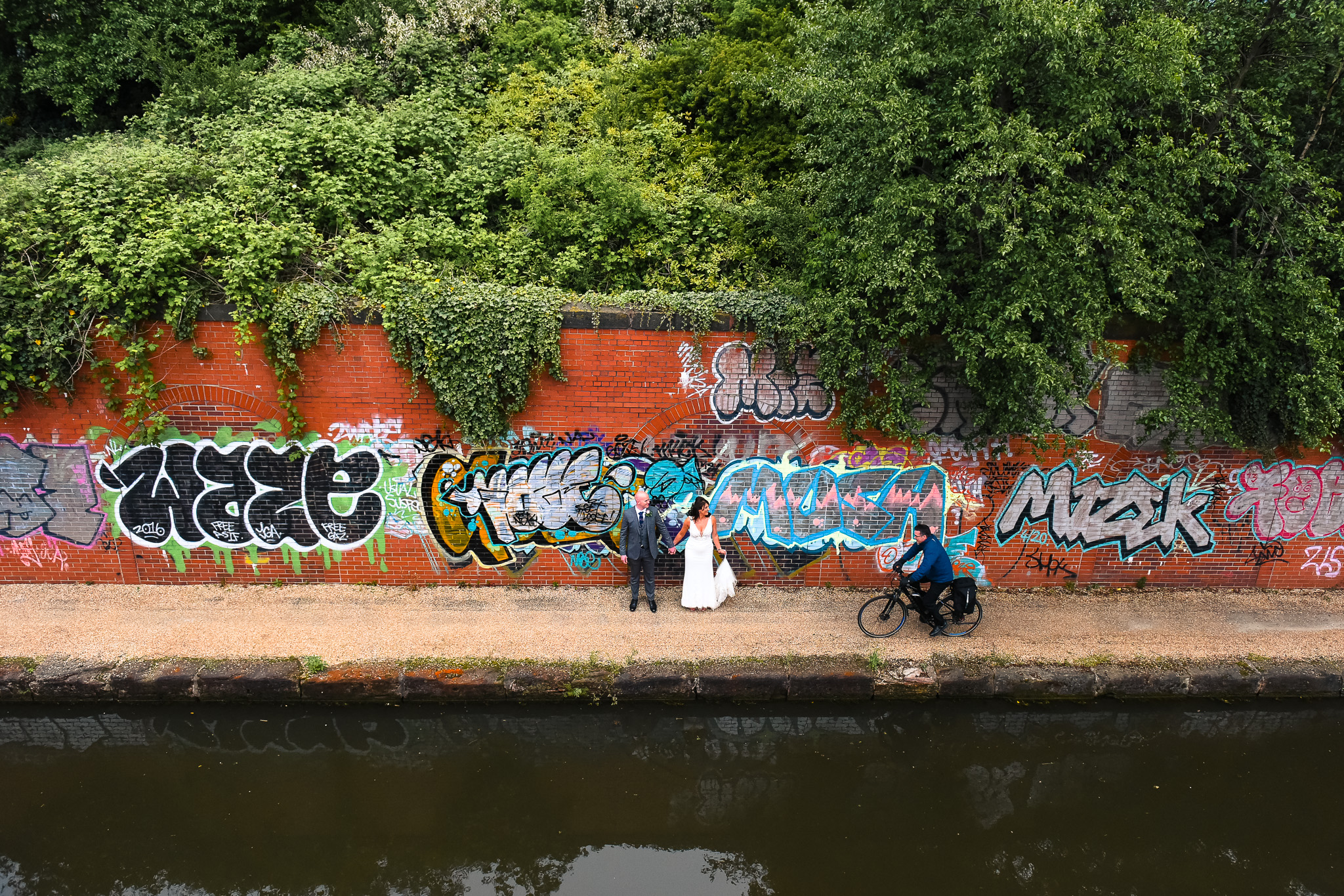 Cyclist passes bride and groom on Manchester canal