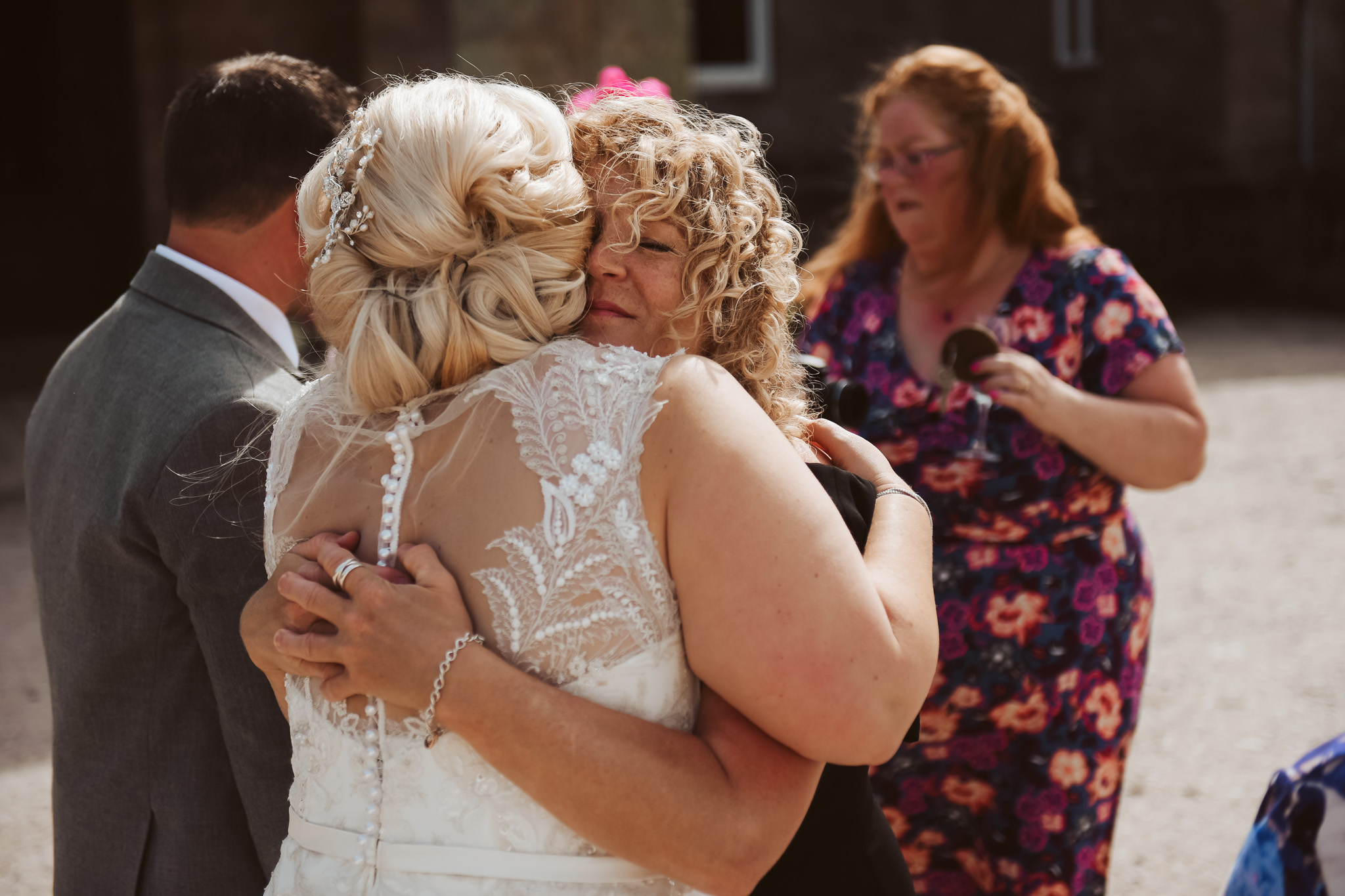 Wedding guests hugging bride