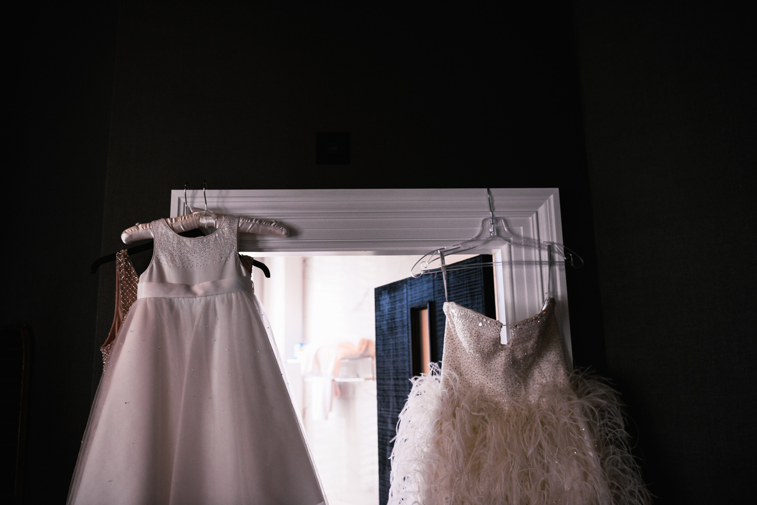 Bride's dress hanging from door frame unposed