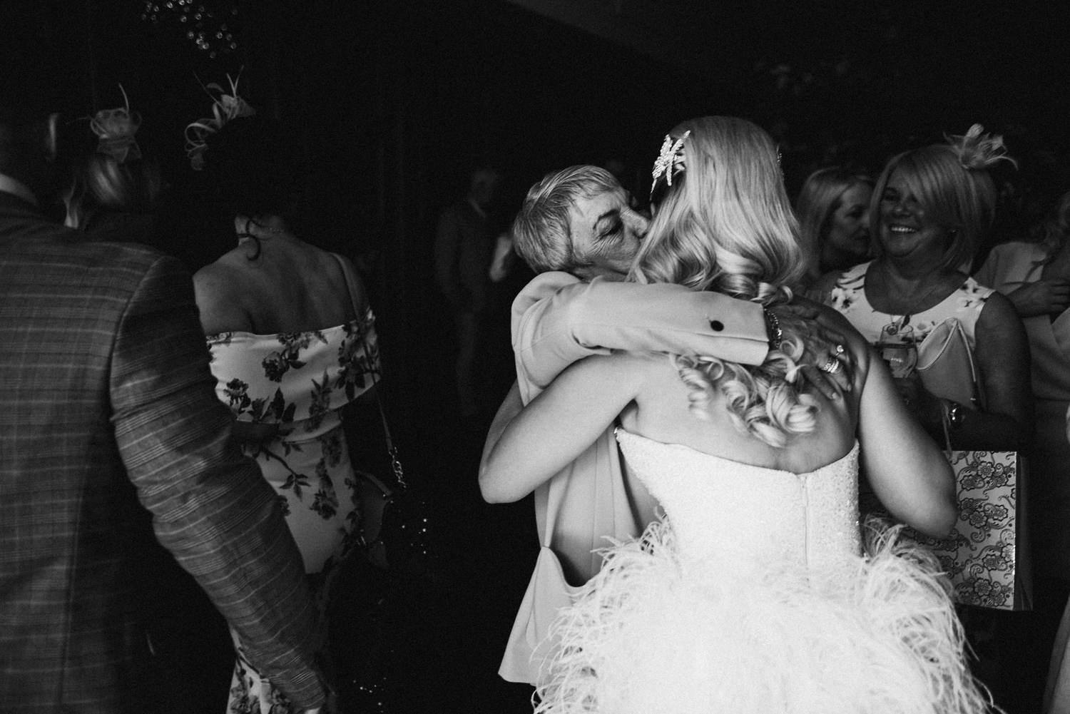 bride being hugged by guests
