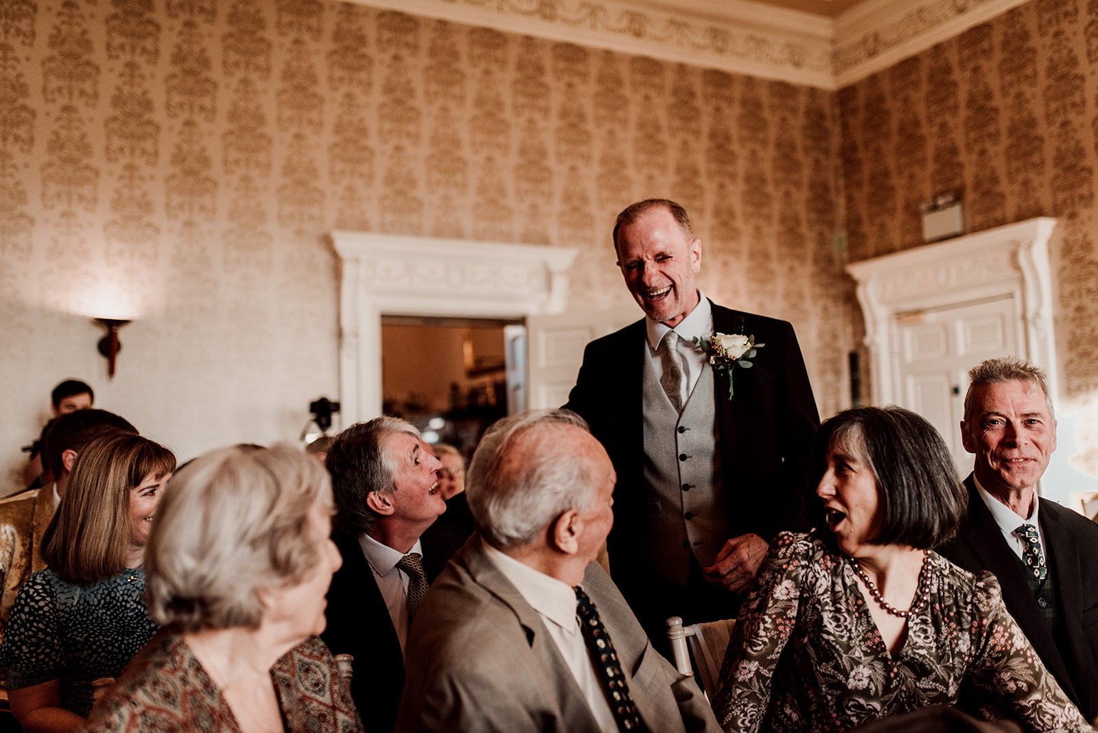 The groom laughing with guests
