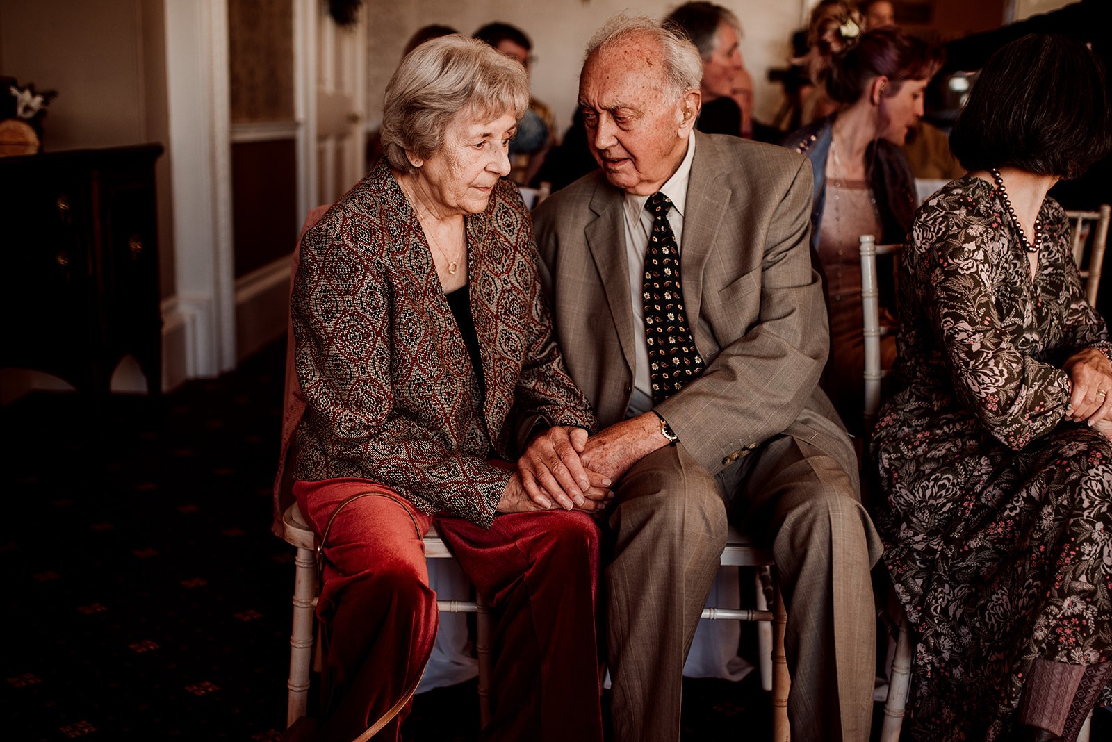 An elderly couple holding hands