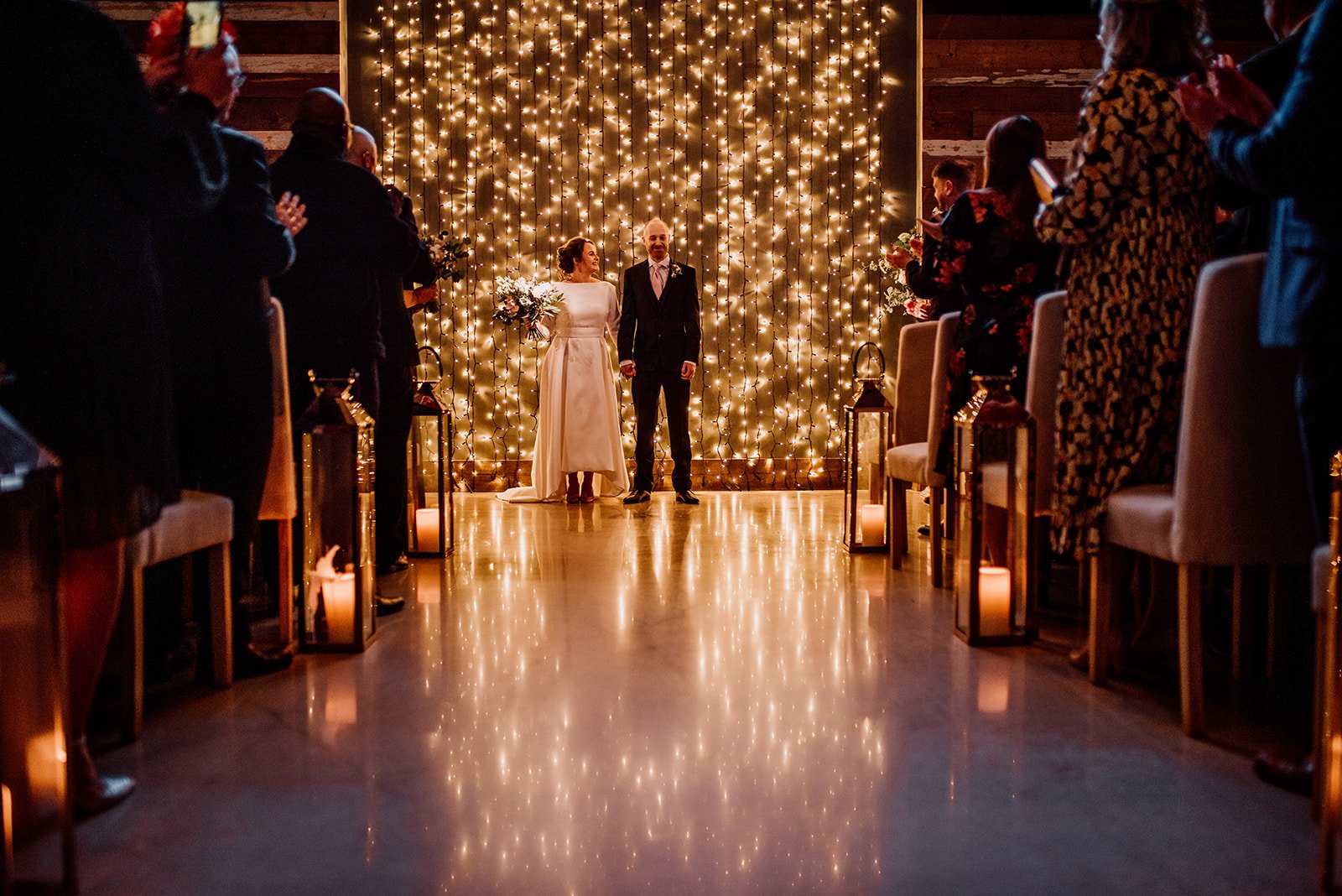 The bride and groom stood in front of the tonnes of fairy lights
