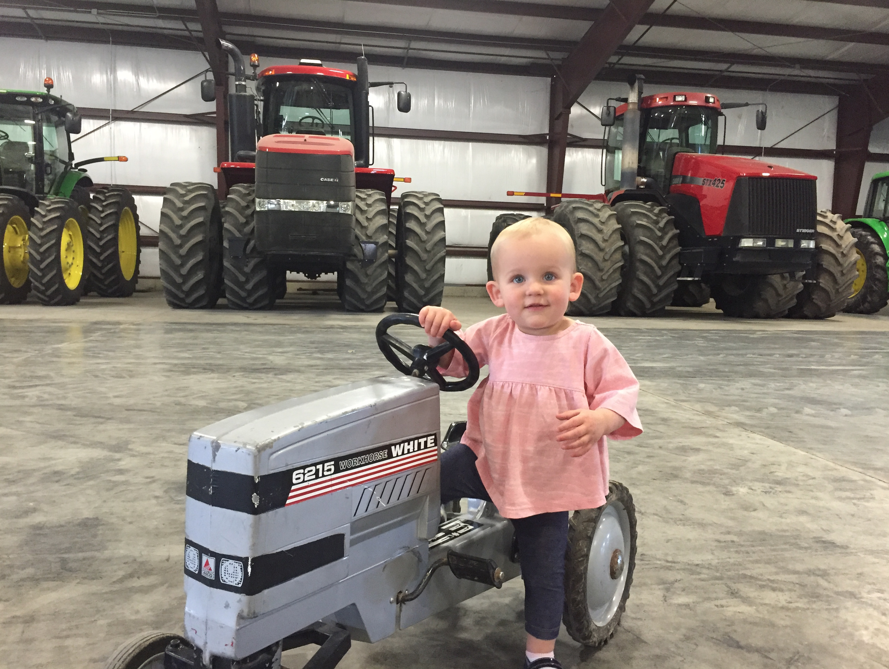 Celine driving her tractor on the farm.png
