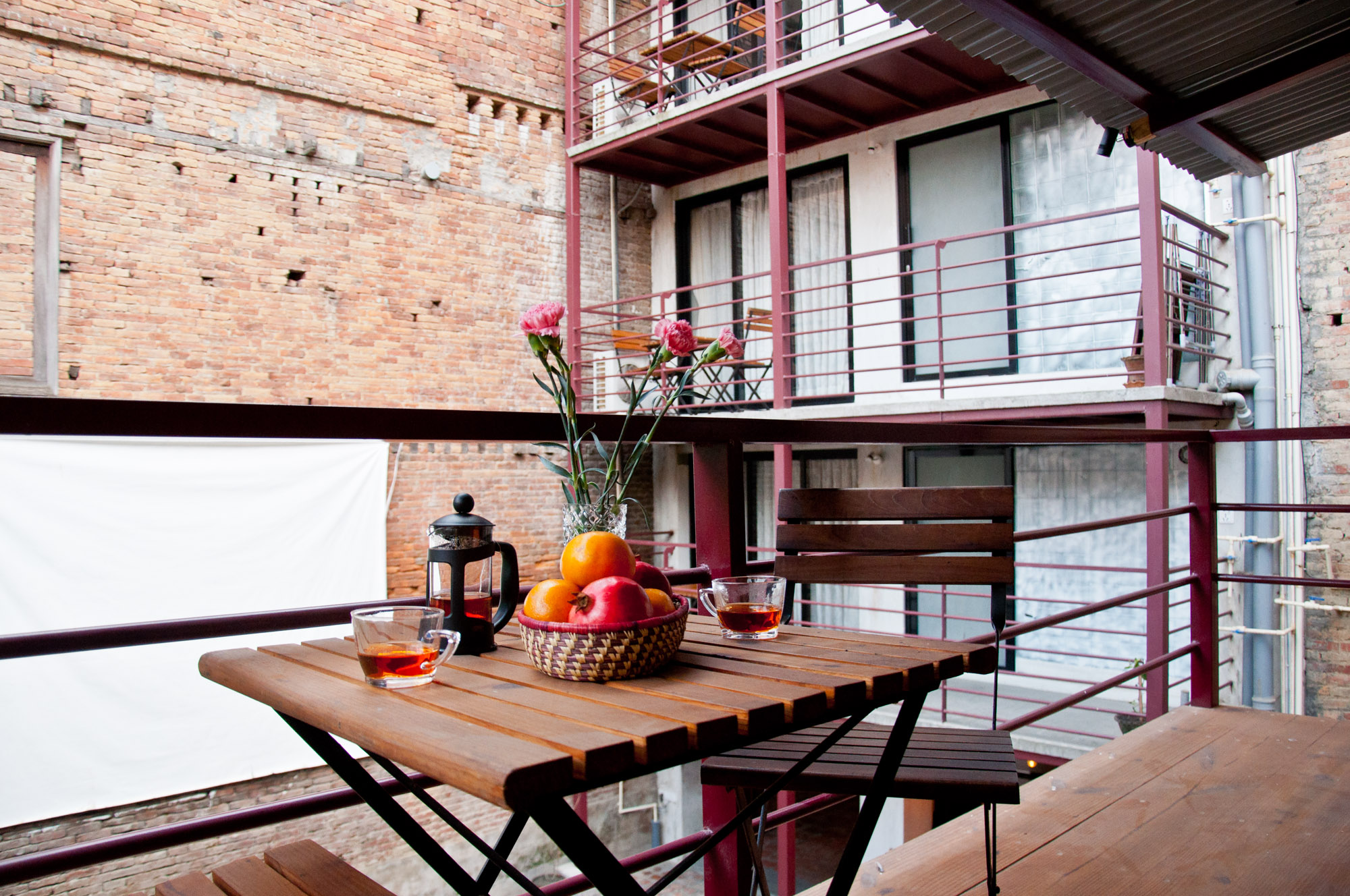 there is a small balcony in courtyard cottage with table-chair setups to enjoy your coffee in peaceful indoor courtyard.