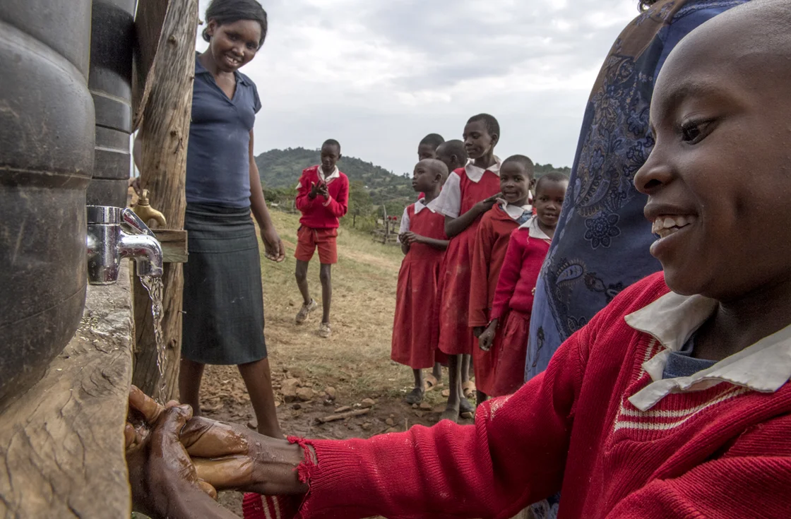 Students at Intimigom Primary School line up before lunch to use the hand washing stations on campus. 