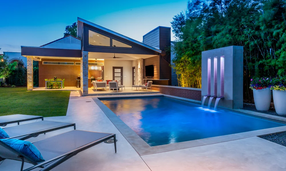 These homeowners wanted to create an entire outdoor oasis. This pool house cabana features a large outdoor kitchen, dining area, entertainment area, and enclosed pool bath. Its proximity to the pool makes it easy to use both areas without feeling much of a separation between the two key outdoor living features.