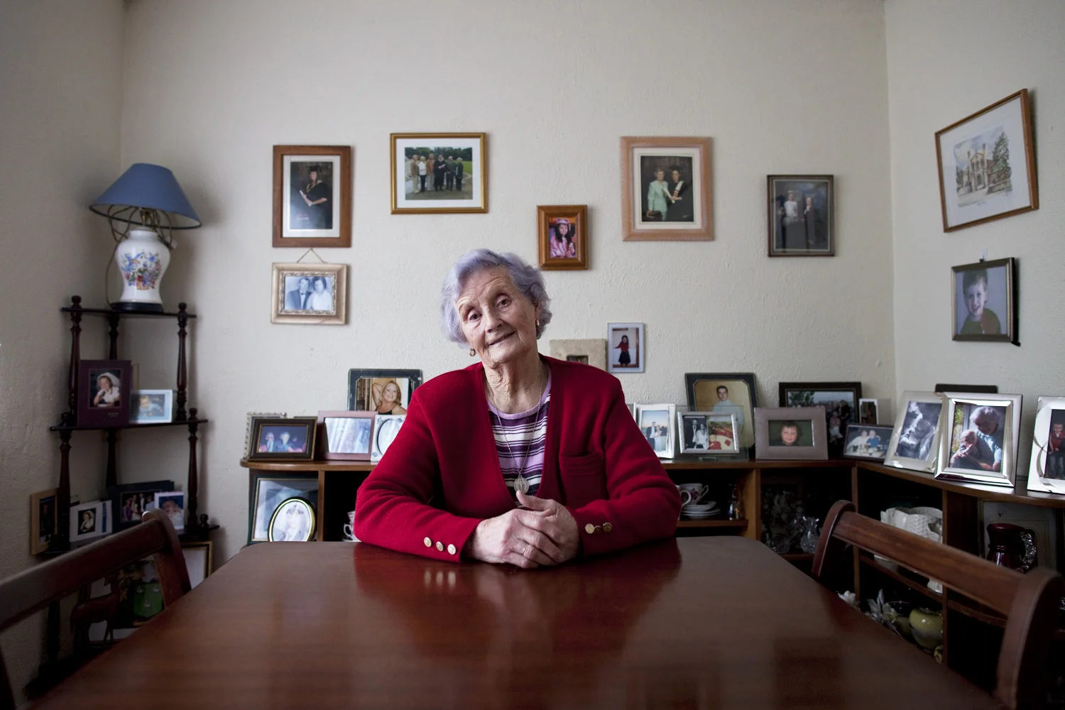 A documentary photograph of a woman sitting at the table in her home in the west of ireland