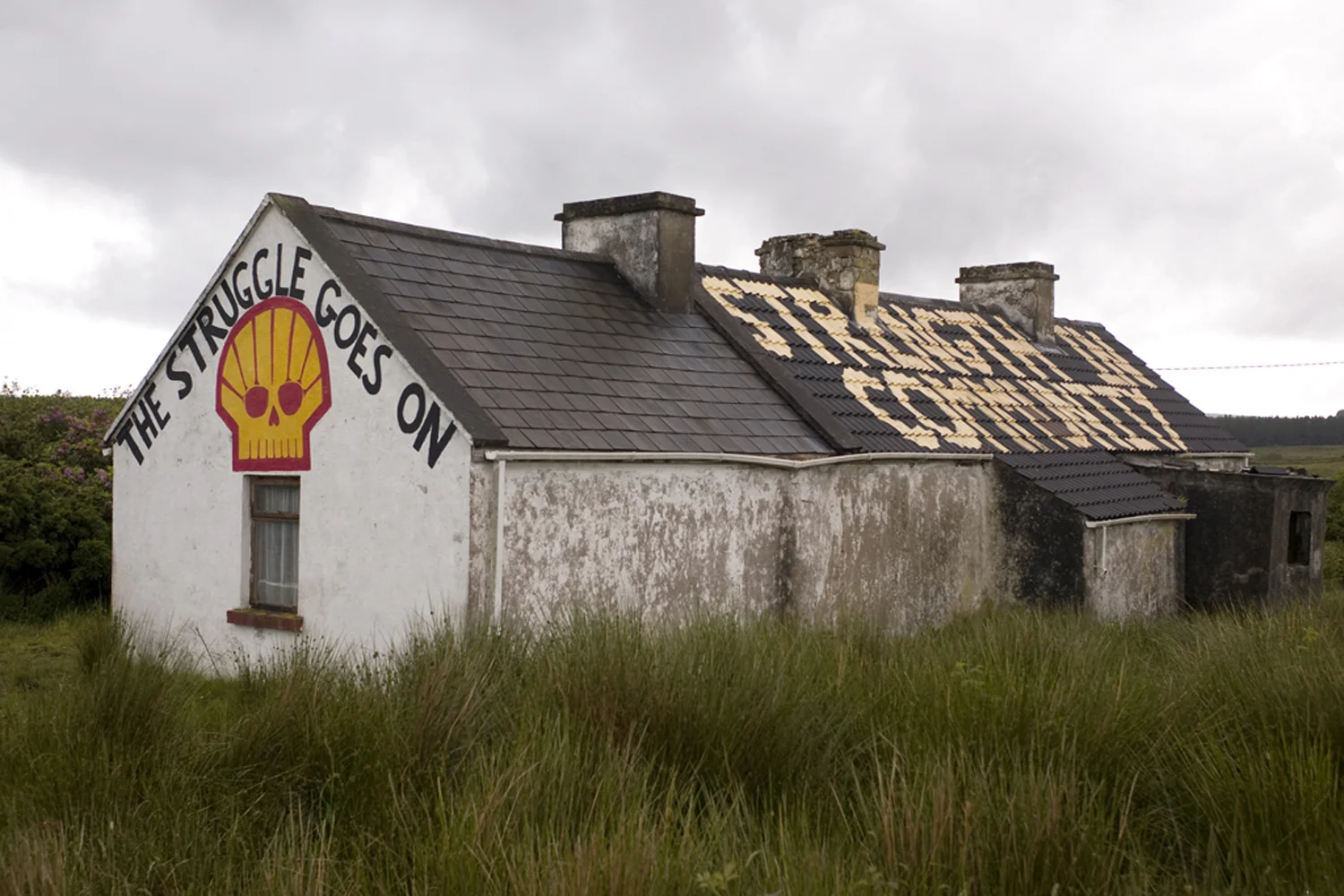 A documentary photograph of an abandoned home painted to promote the fight against shell moving into ireland