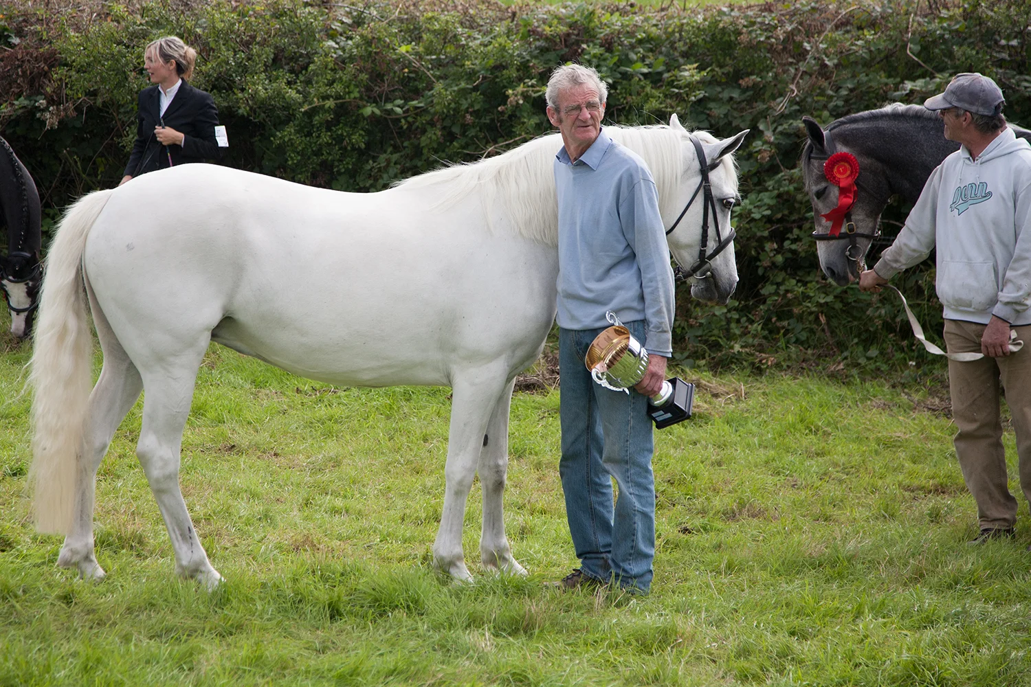 A documentary photograph of man standing beside his award winning horse at an agricultural show in the west of ireland