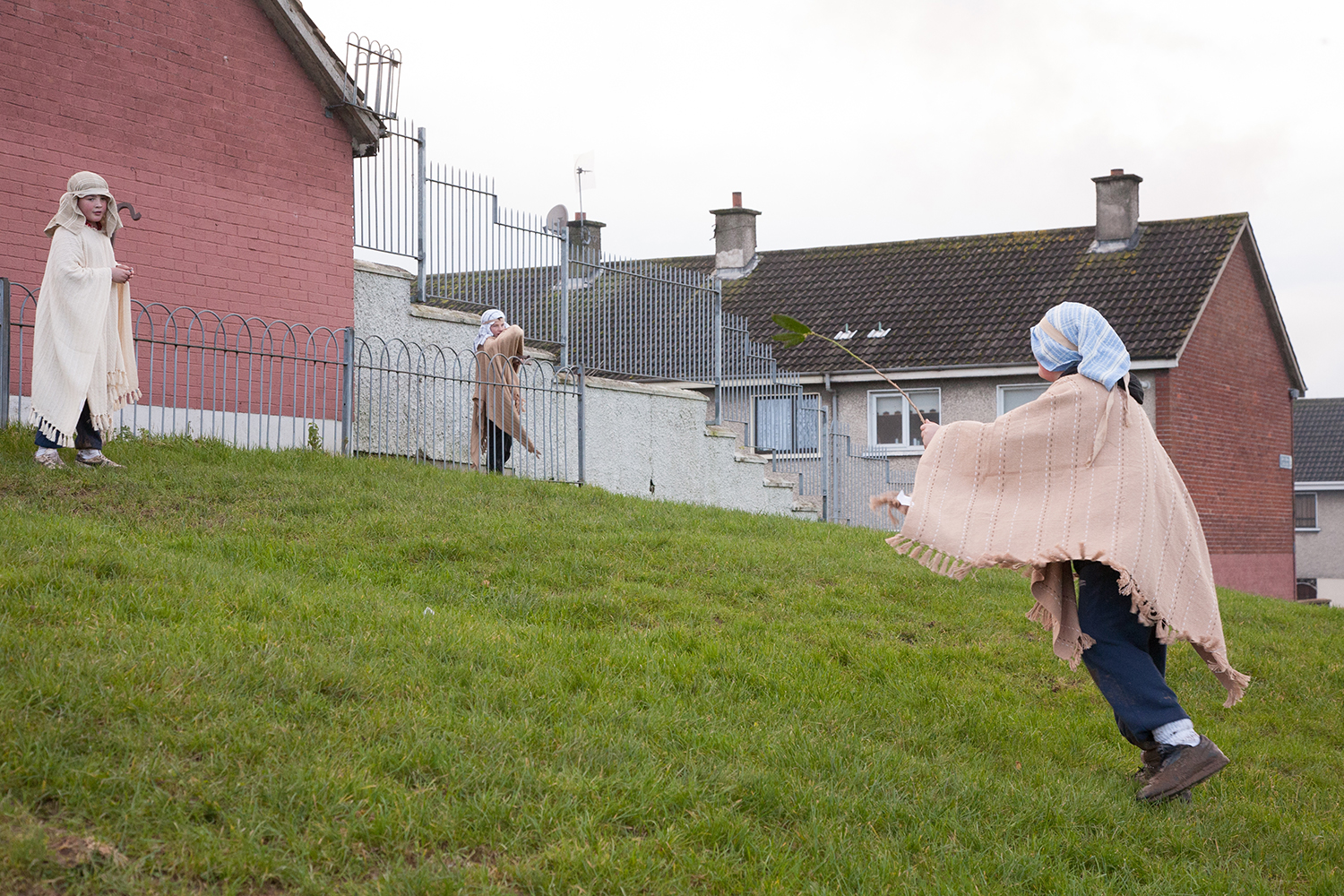 A documentary photograph of three boys playing before they help perform a live nativity scene with monks in Moyross, Limerick, Ireland
