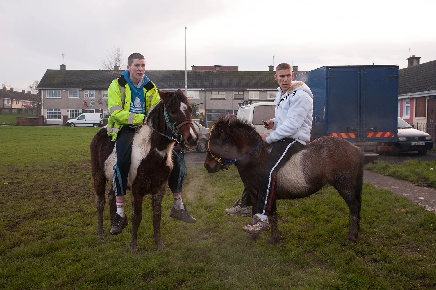 A documentary photograph of two older teenager boys sitting on ponies in moyross, Limerick, Ireland