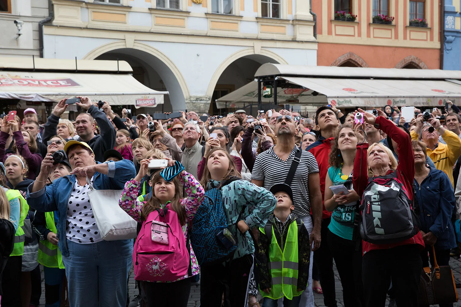 A documentary photograph of tourist taking photograph of famous clock in Prague, Czech Republic
