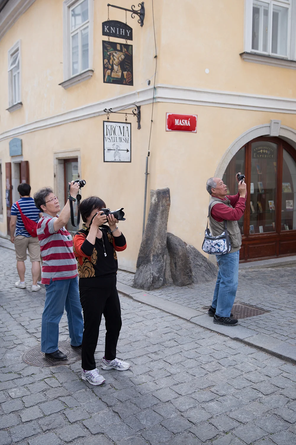 A documentary photograph of tourist taking photographs in the streets of cesky krumlov, czech republic