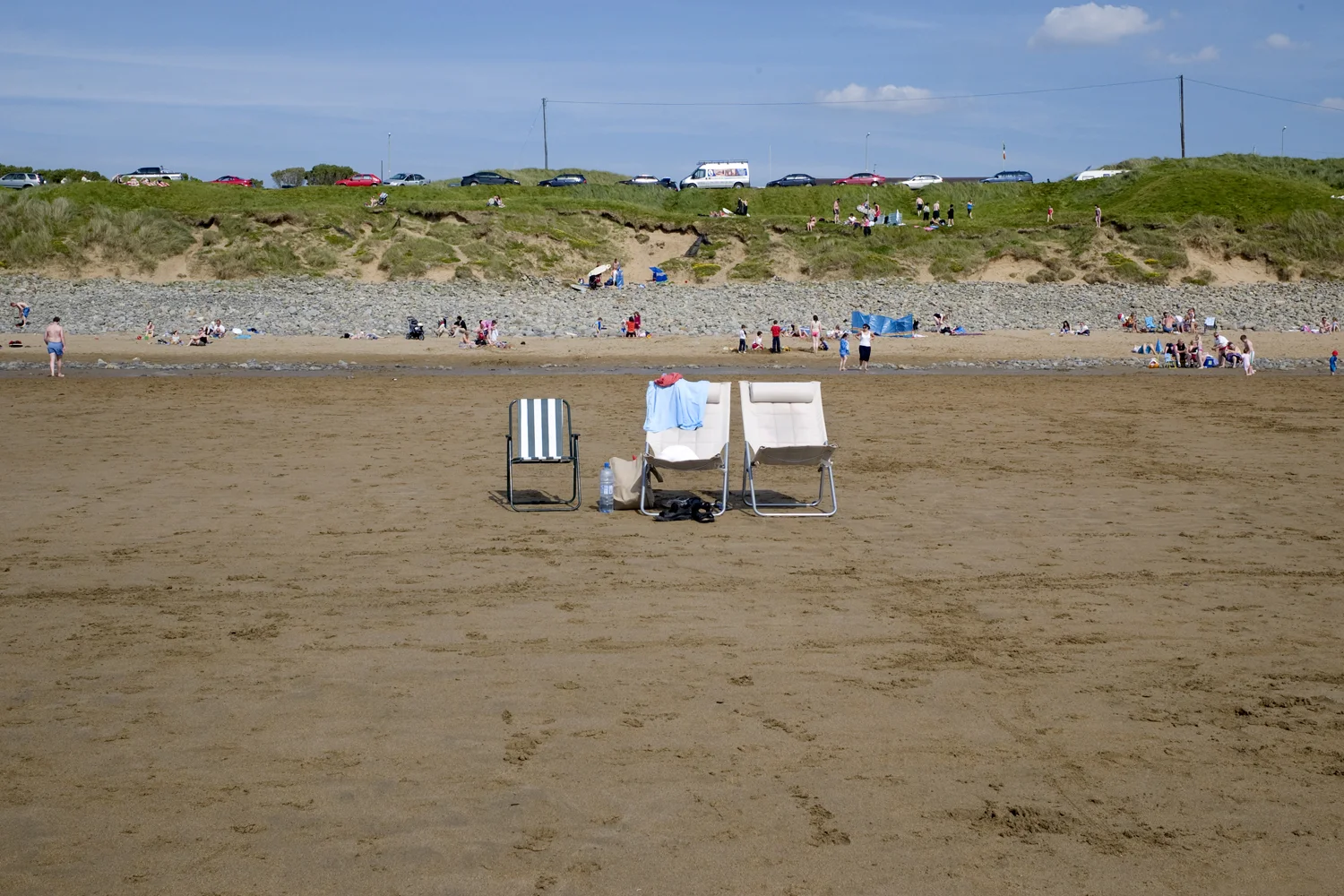 A documentary photograph of lawn chairs on the beach in Ireland