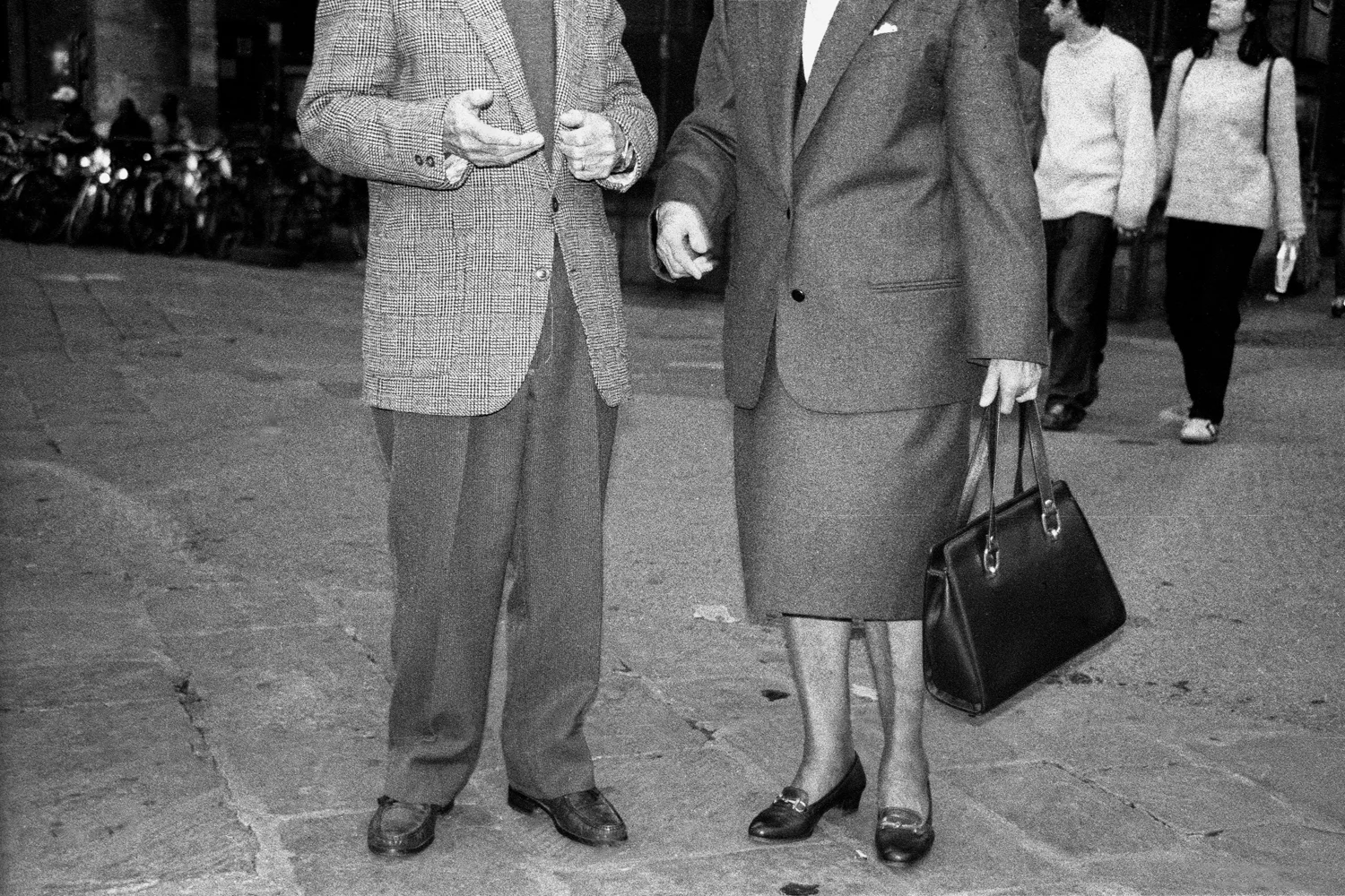 A documentary photograph of an older couple talking with one another in italy