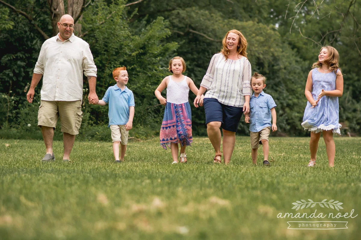 redhead-family-of-six-in-blue-walking-in-field