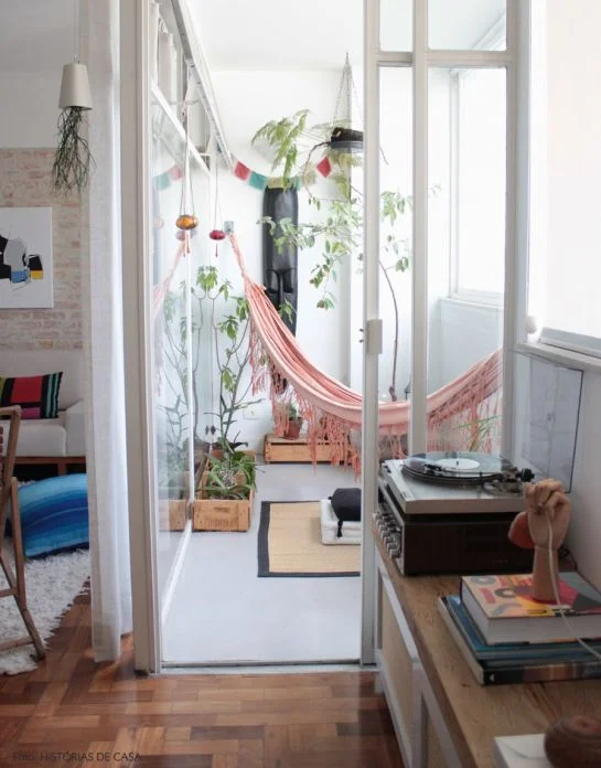 Plants and accents (like hammocks!) transform enclosed, light-filled spaces. | via "8 Tiny But Amazing Balcony Garden Spaces." Refinery 29