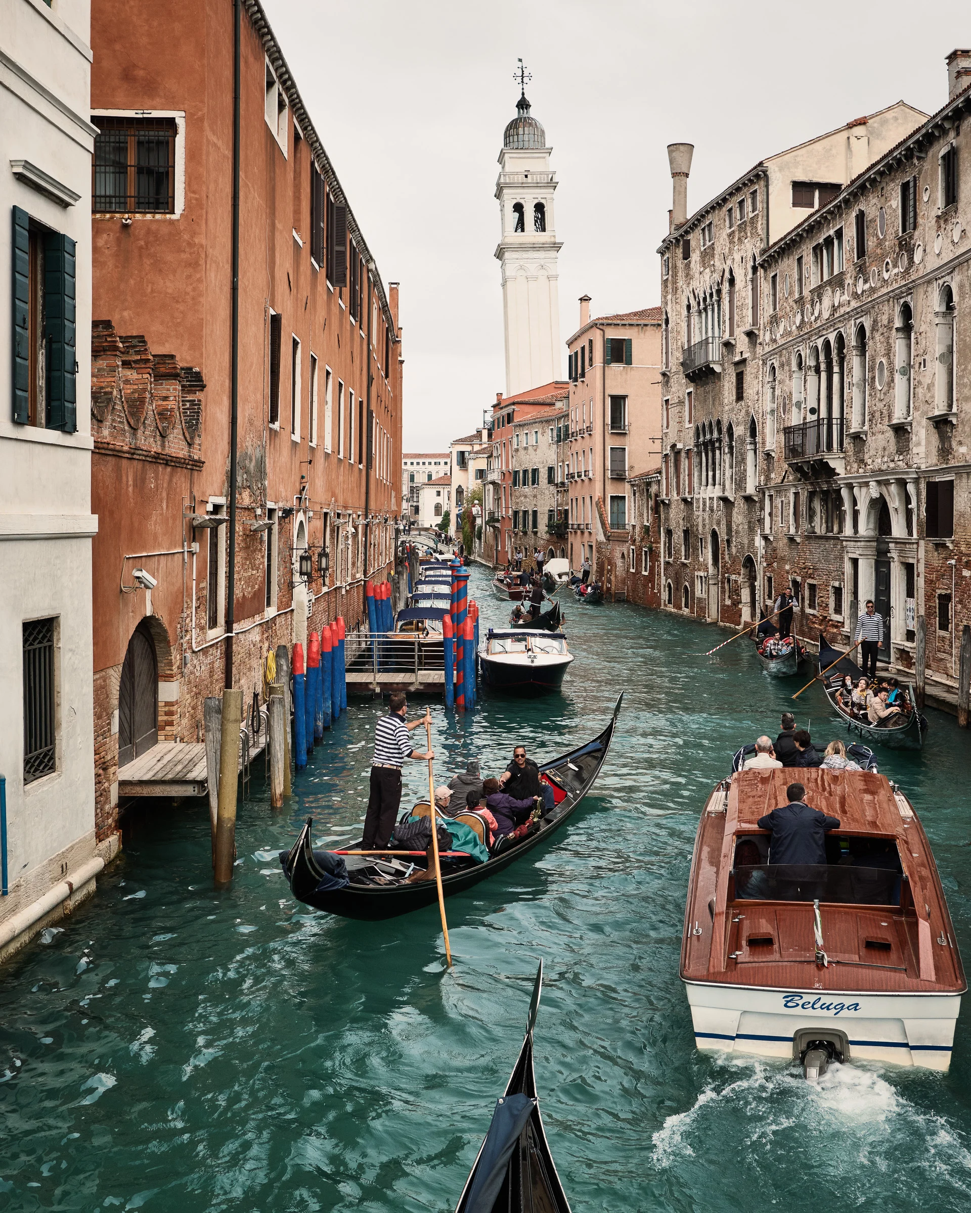 Gondolas and boats on the canals and Venice's leaning tower.
