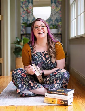 Nicolle Wargo-Boswell, LPC, laughing with a stack of books