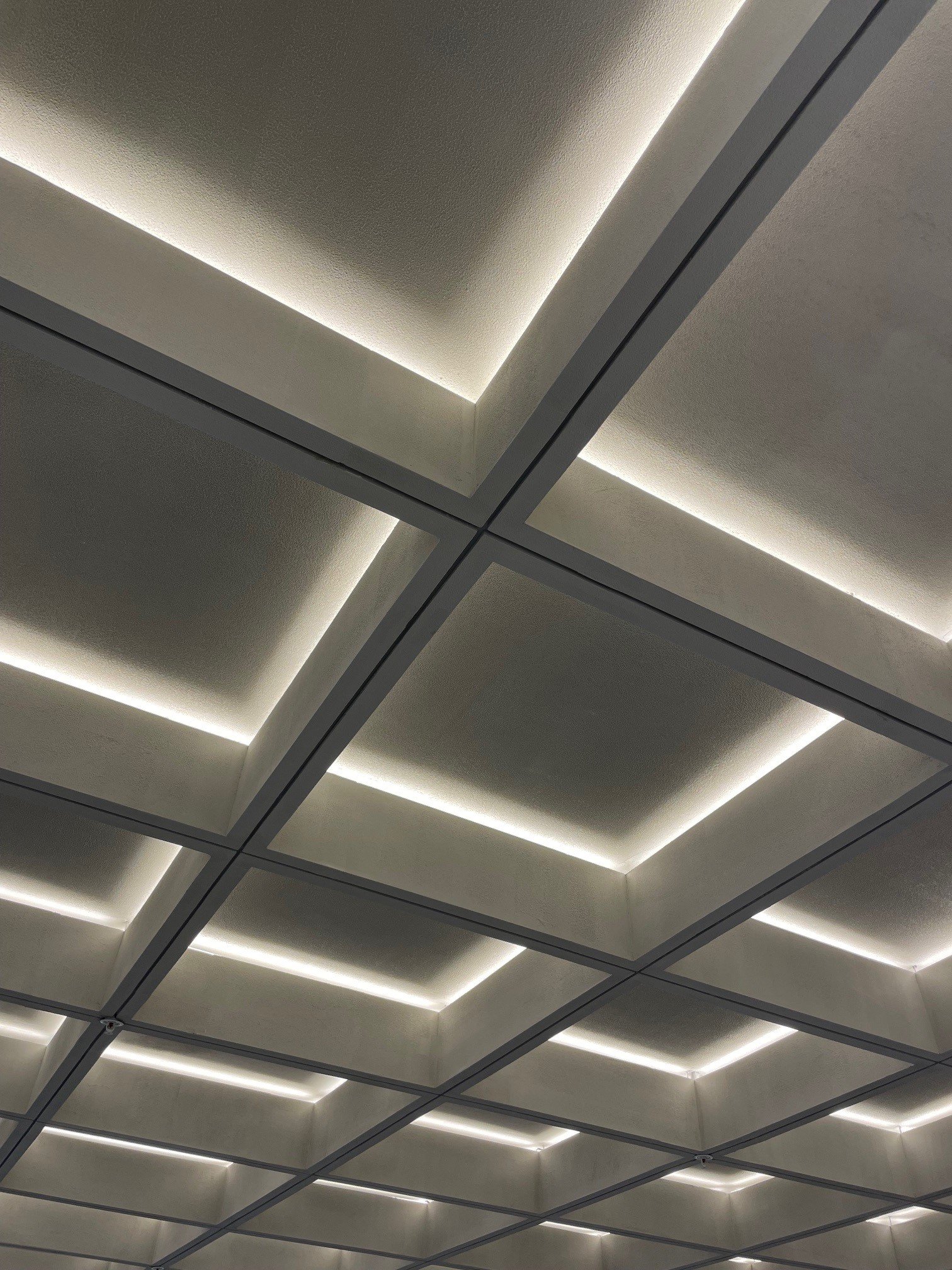 Plafond moderne avec lumières LED intégrées dans un motif géométrique