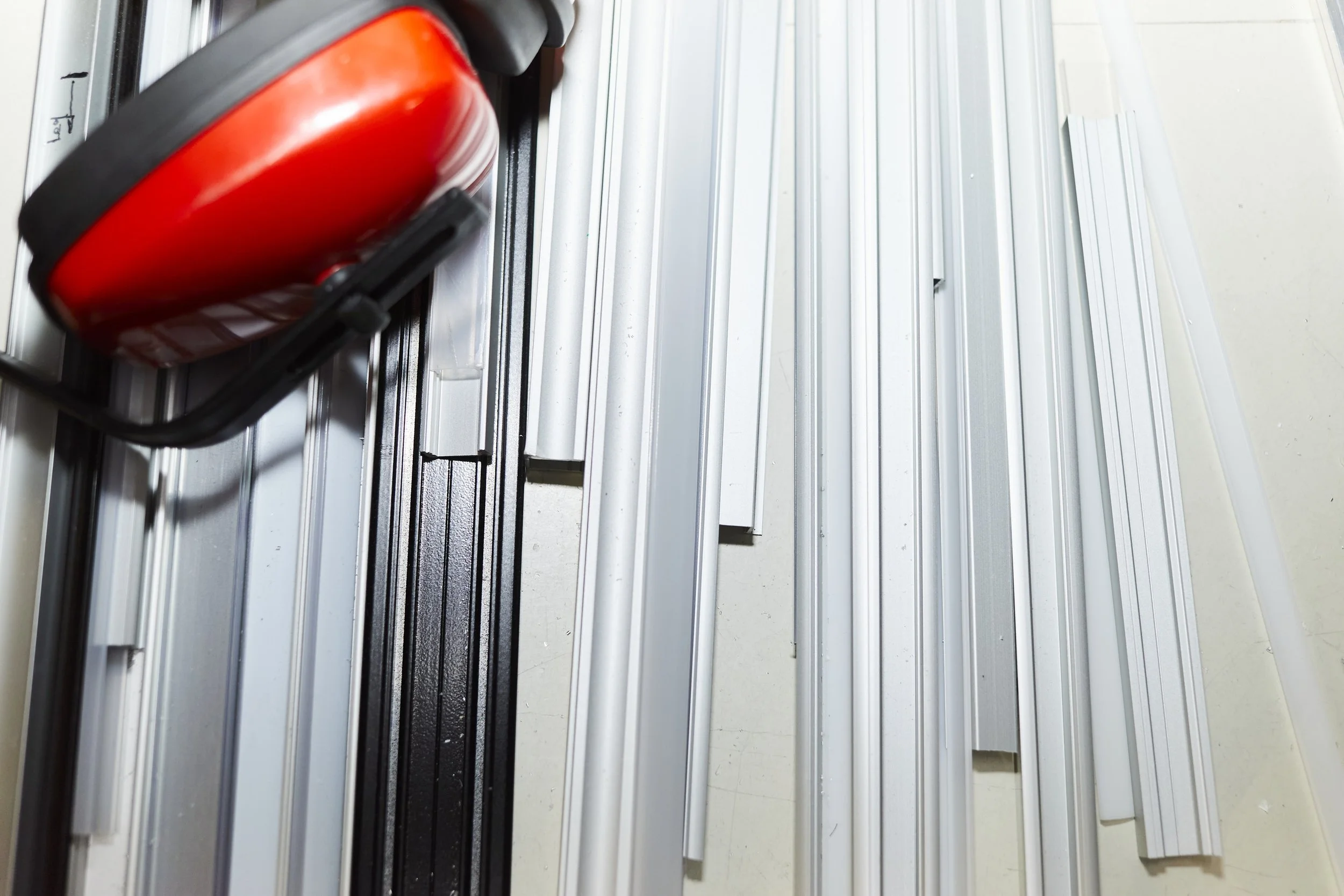 Panneau métallique avec profilés en aluminium et un boîtier rouge fixé à un rail.