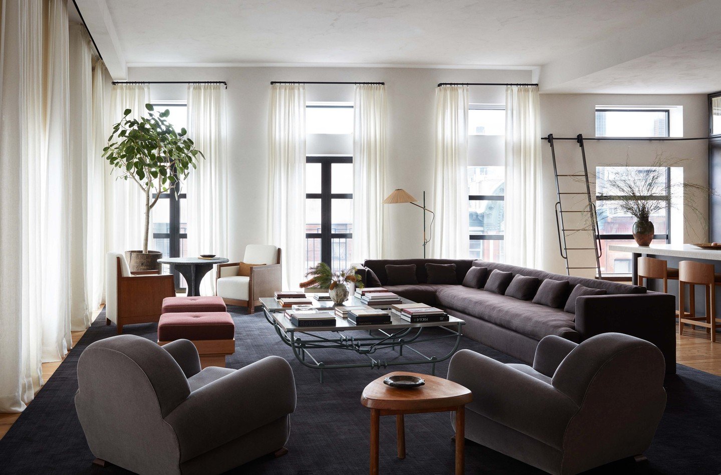 In this designer spotlight, layered seating arrangements and generous negative space give this living room its effortless flow. @augusta.hoffman pairs tailored upholstery with organic elements - stone, wood, and ceramics - to create balance and visua