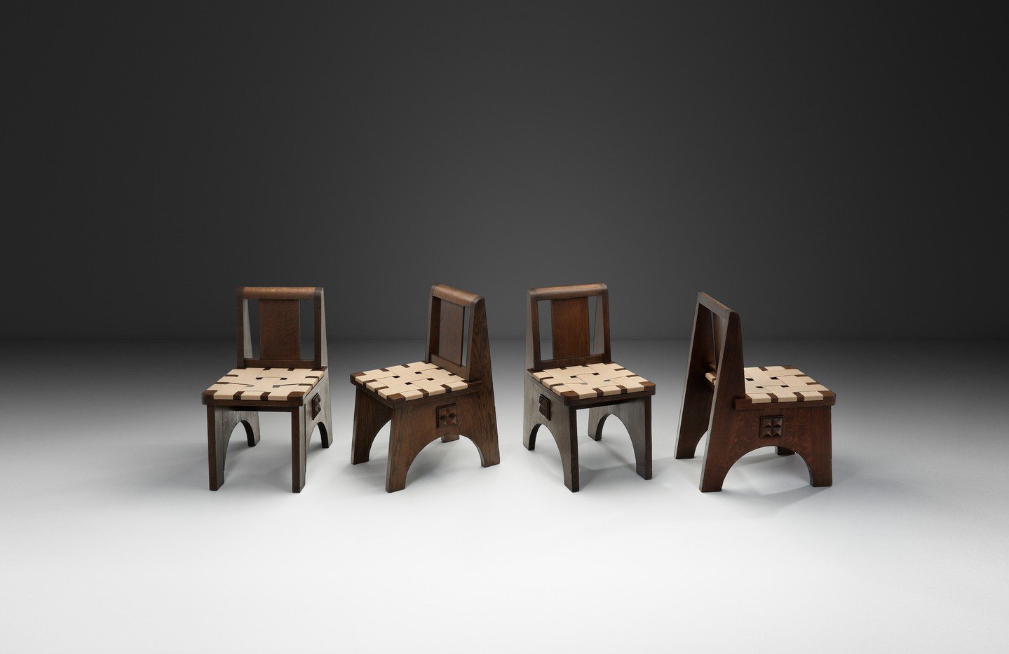 A striking set of four dining chairs, designed in the manner of Charles Dudouyt, one of the most distinctive figures in French decorative arts of the interwar period. Dudouyt&rsquo;s work is often celebrated for its rustic charm, and masterful handli
