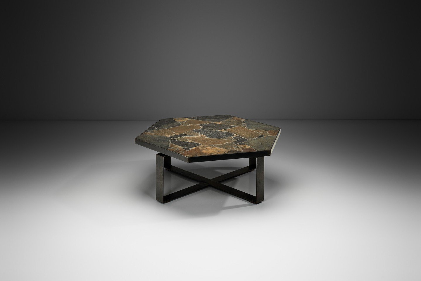 Rooted in the bold language of Brutalist design, this coffee table stands out through its strong geometry and sculptural presence.⁠
⁠
The hexagonal top is composed of a mosaic of natural stone, rich in tonal variation and texture, creating a dynamic 