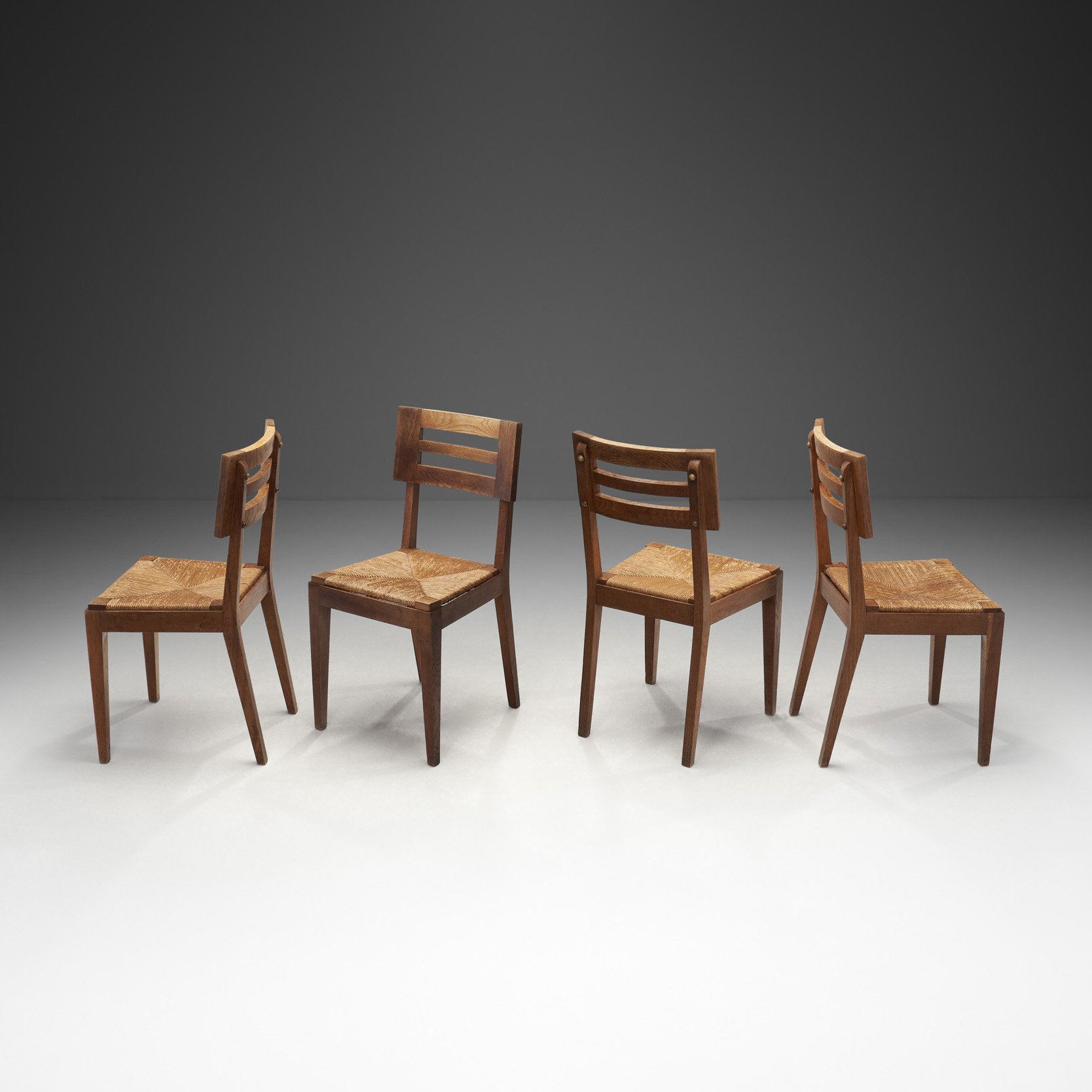 A Set of Four Dining Chairs with Woven Seats by Pierre Cruège, France ca 1950s (sold)