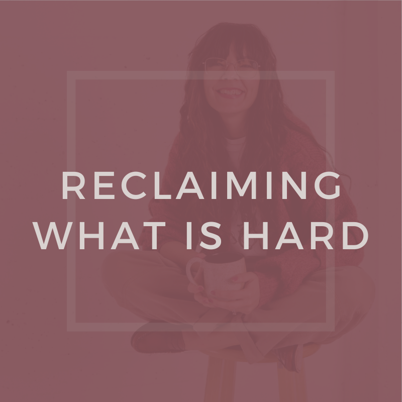 A woman sitting cross-legged on a stool, holding a mug, smiling, with text overlay that reads 'Reclaiming What Is Hard'.