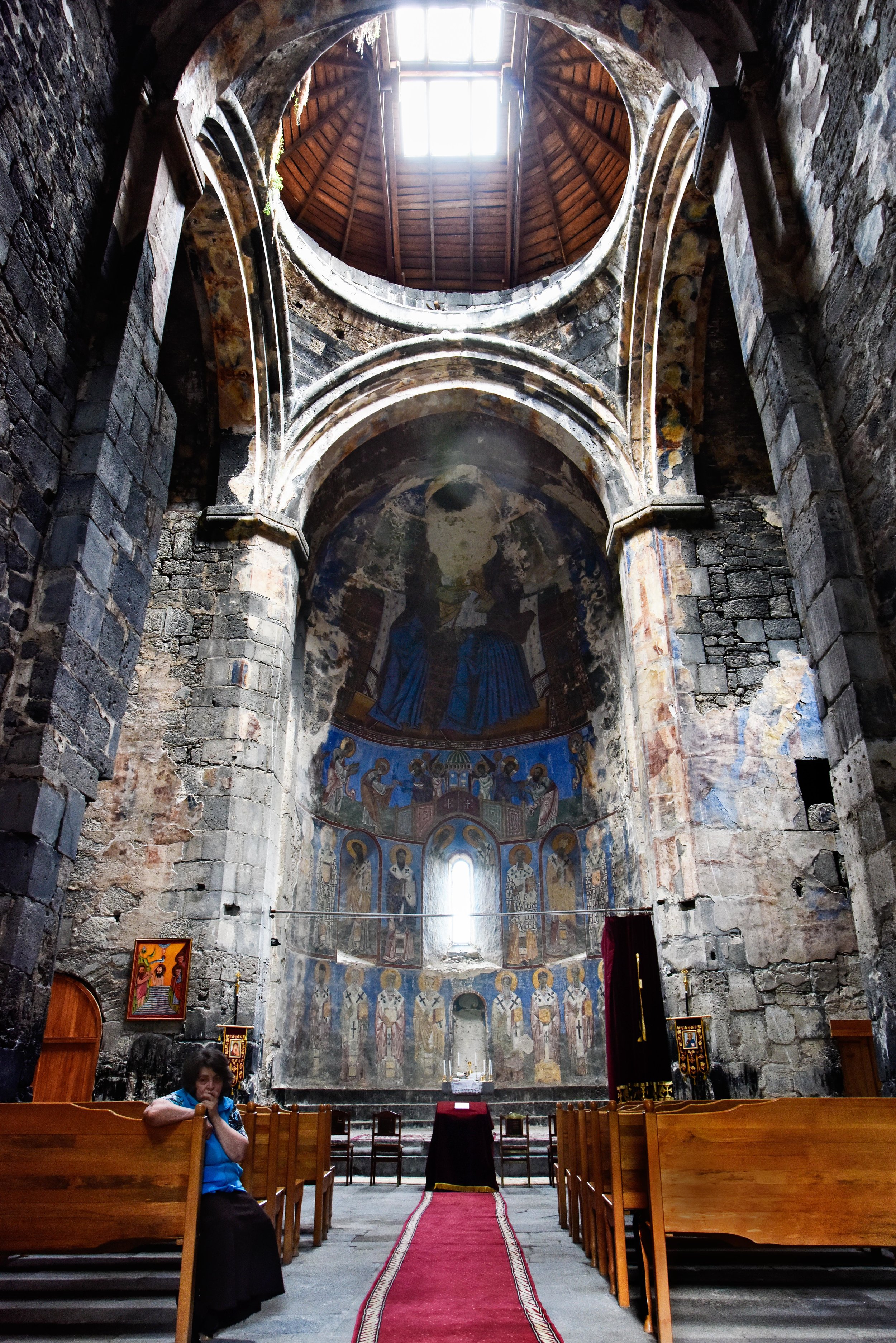 The caretaker shows us the place where a Mongol cannonball went through the face of St. Mary above and behind the altar