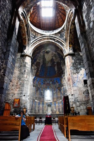 The caretaker shows us the place where a Mongol cannonball went through the face of St. Mary above and behind the altar