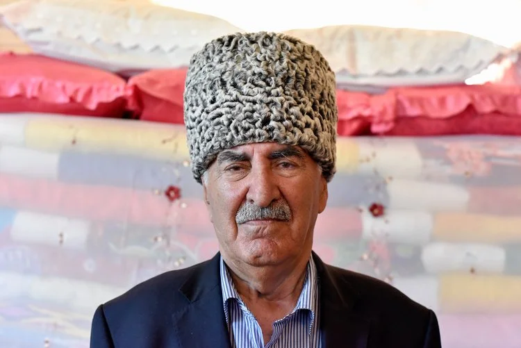 Aziz Tamoyan in front of his bedsheet display